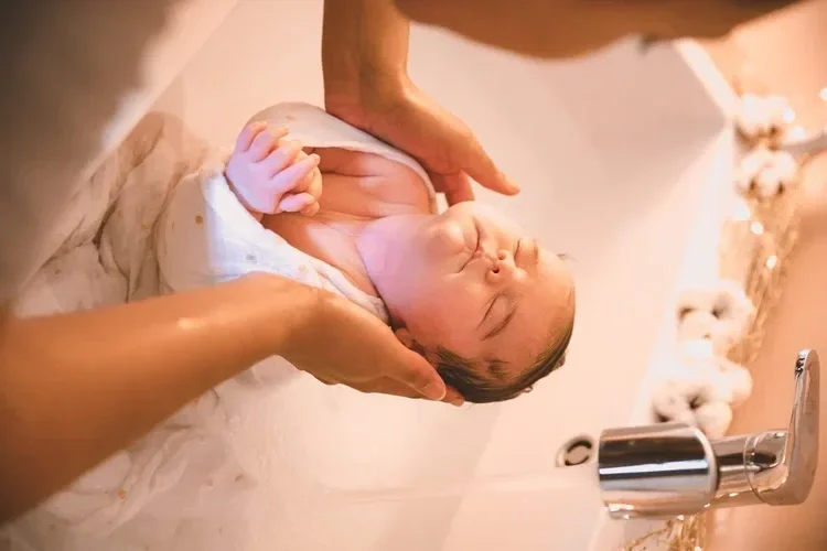 Newborn soothed during a wrapped thalassotherapy bath performed by a doula from Ys&eacute; Naissance in Montreal