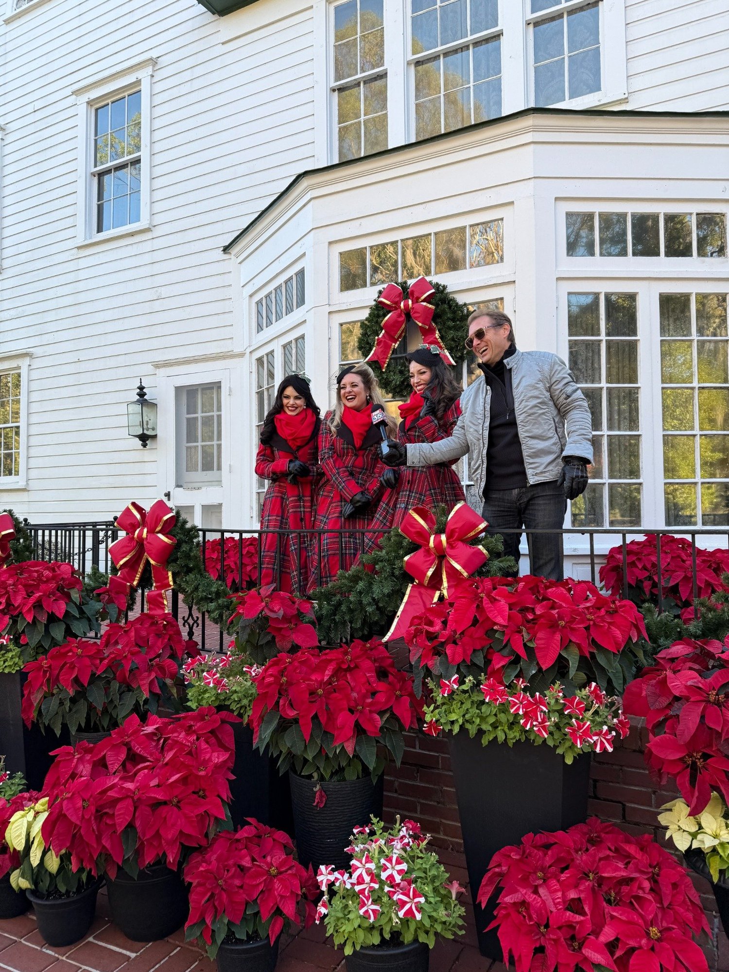 Leu Gardens team members surrounded by rows of red poinsettias