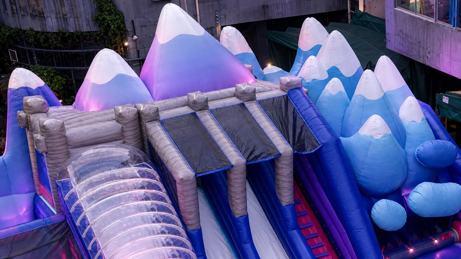 Completed inflatable mountain façade illuminated in icy blue and purple