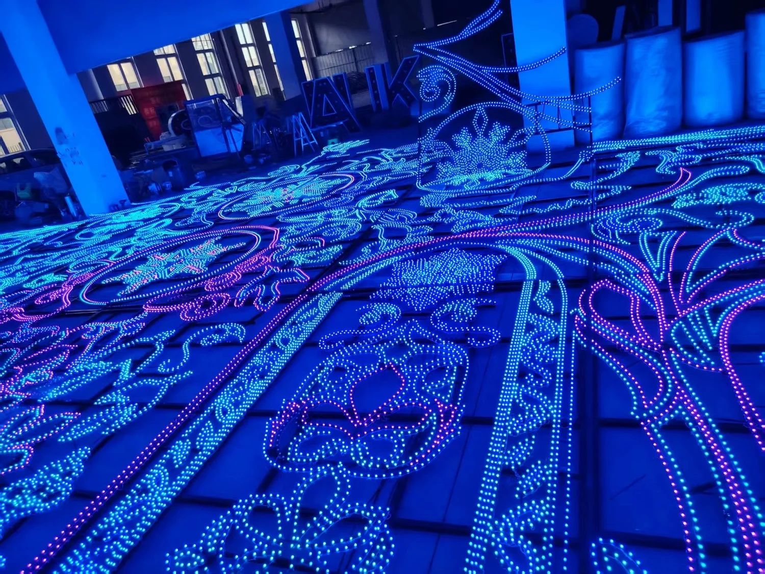 Large illuminated sections of the blue and violet wildlife mural laid across a workshop floor for inspection