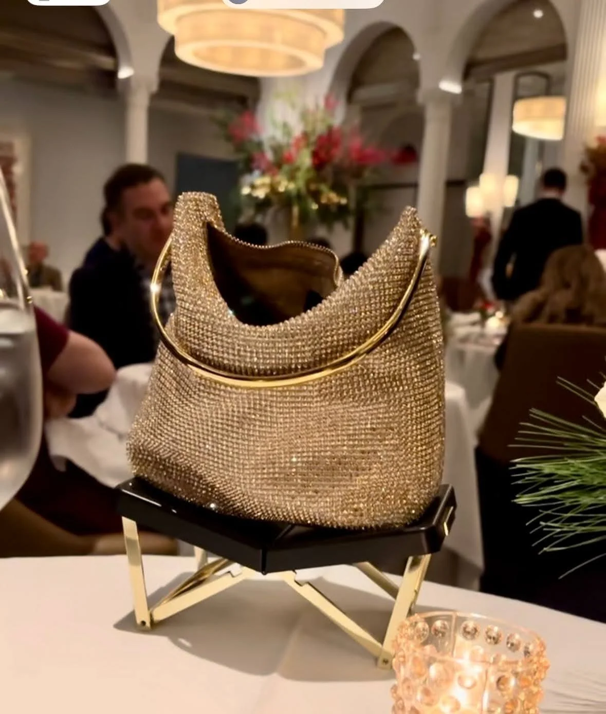 Gold bag resting on a BAGCEIT® purse stand on the table