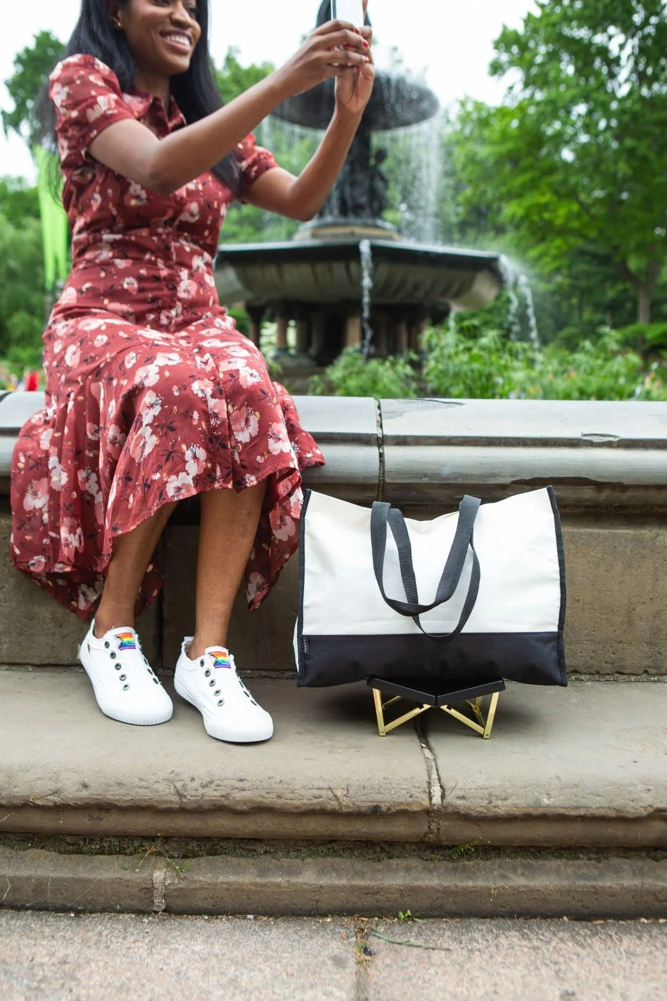 White canvas bag resting on a BAGCEIT® purse stand on the ground