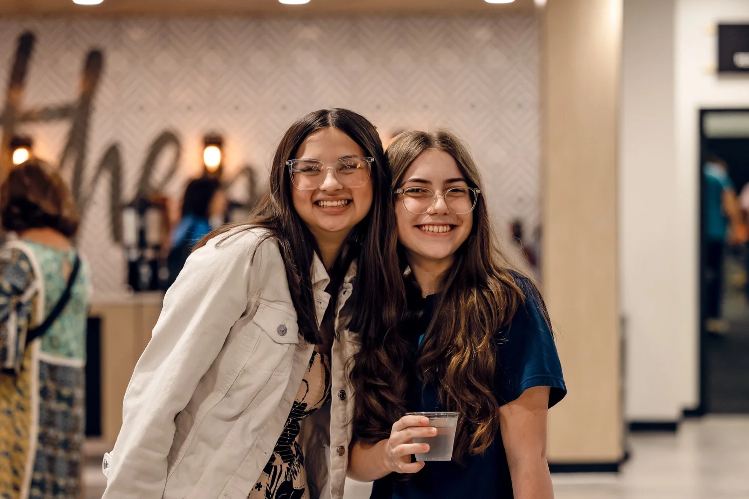 Two students smiling together in the lobby at Anthem Church