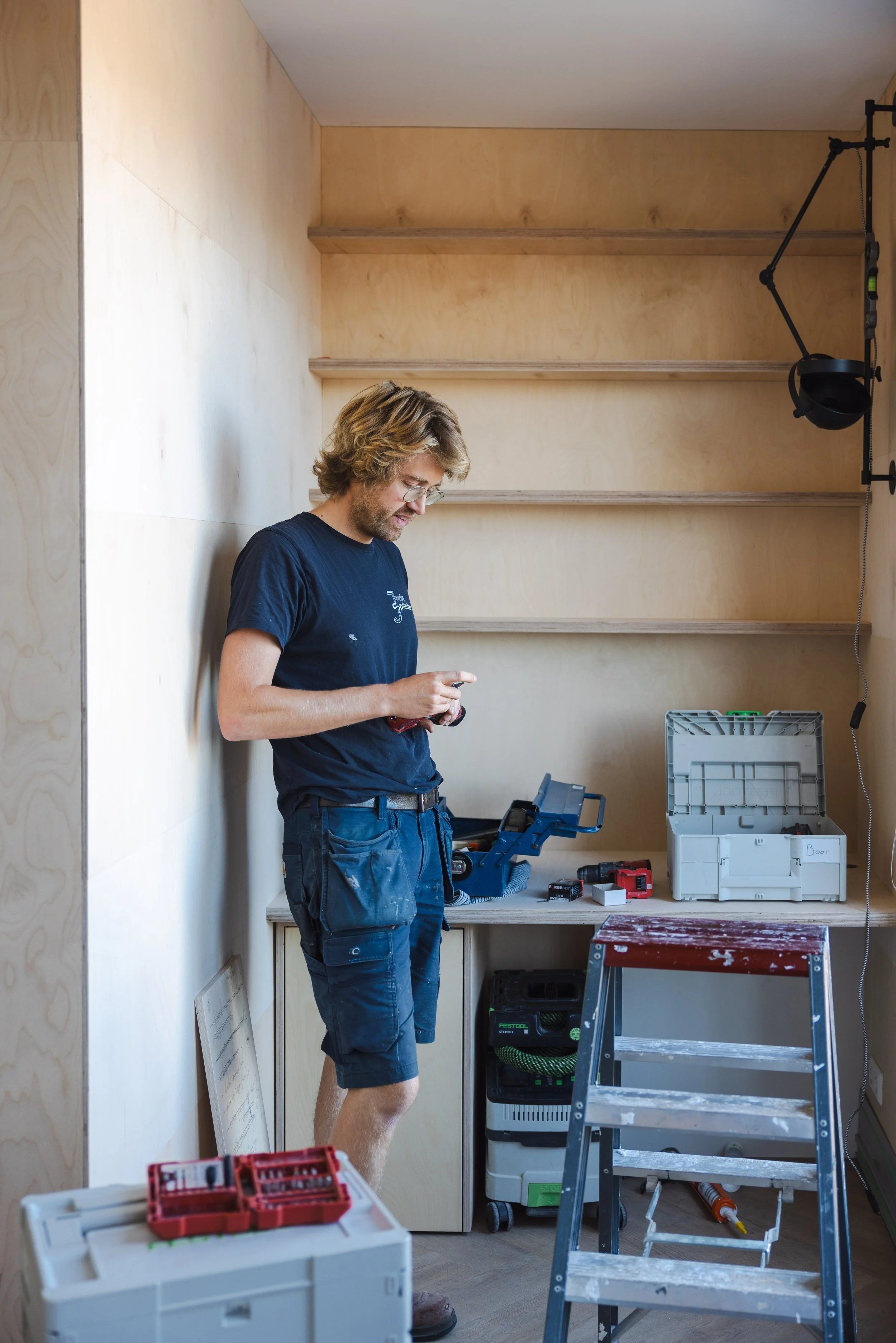 Hoogslaper van blank hout met ladder, gemonteerd tussen twee muren voor de ramen