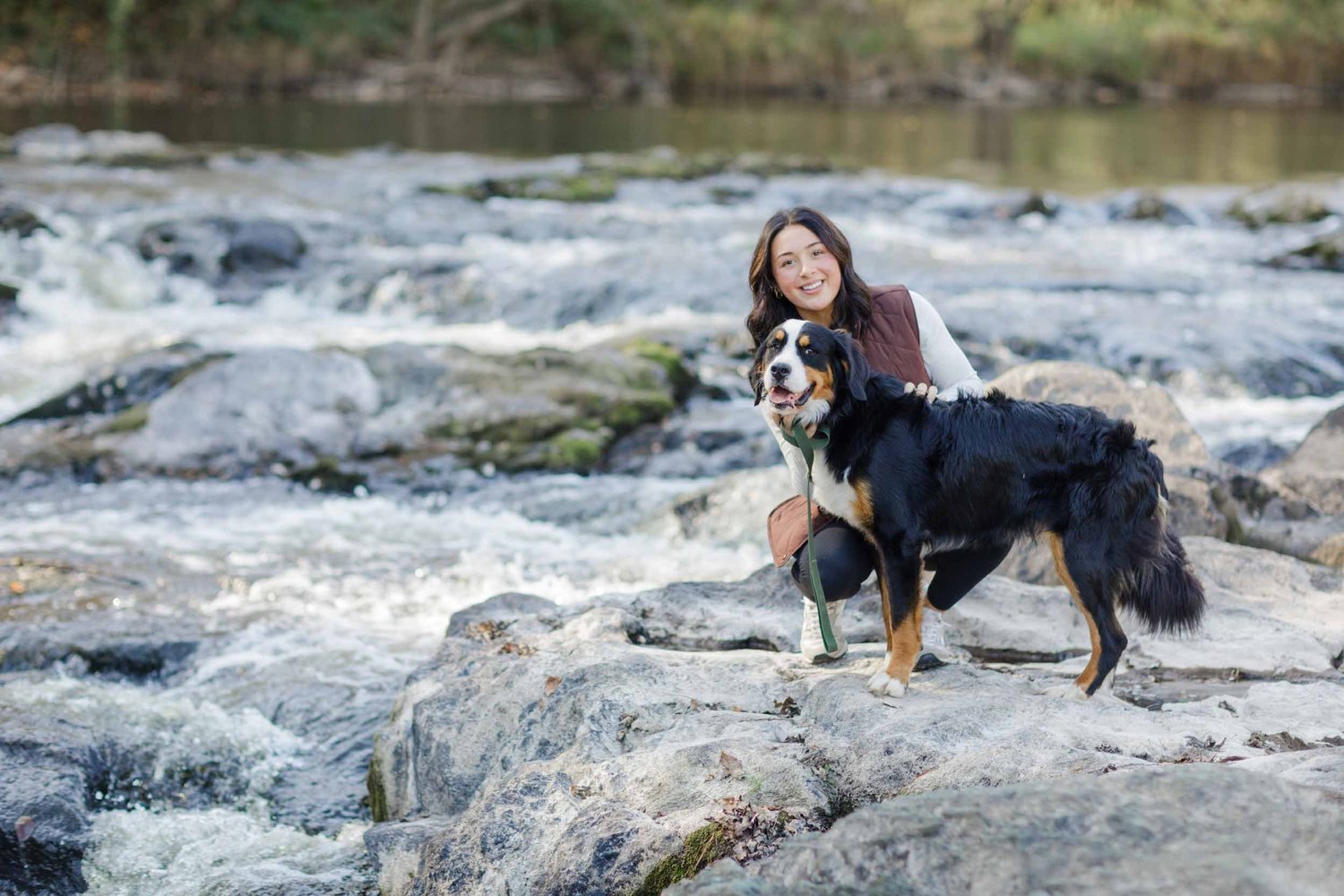 Katie Stokes standing with an adult Bernese in the river at Rib Falls, Wisconsin.