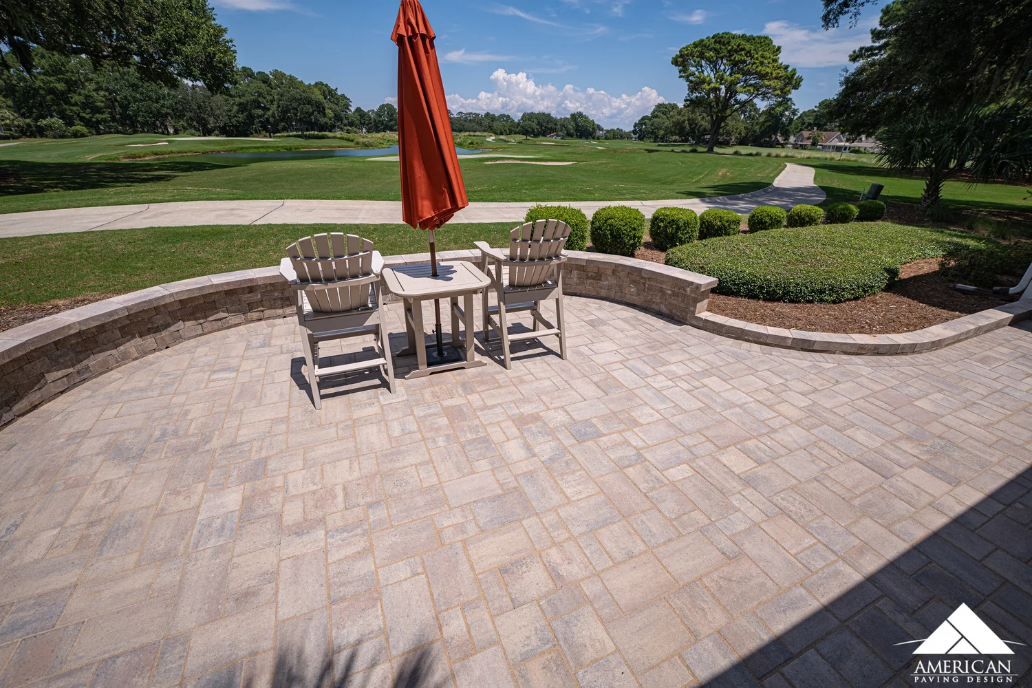 Paver patio with curved seating wall overlooking a golf course in Bluffton, SC