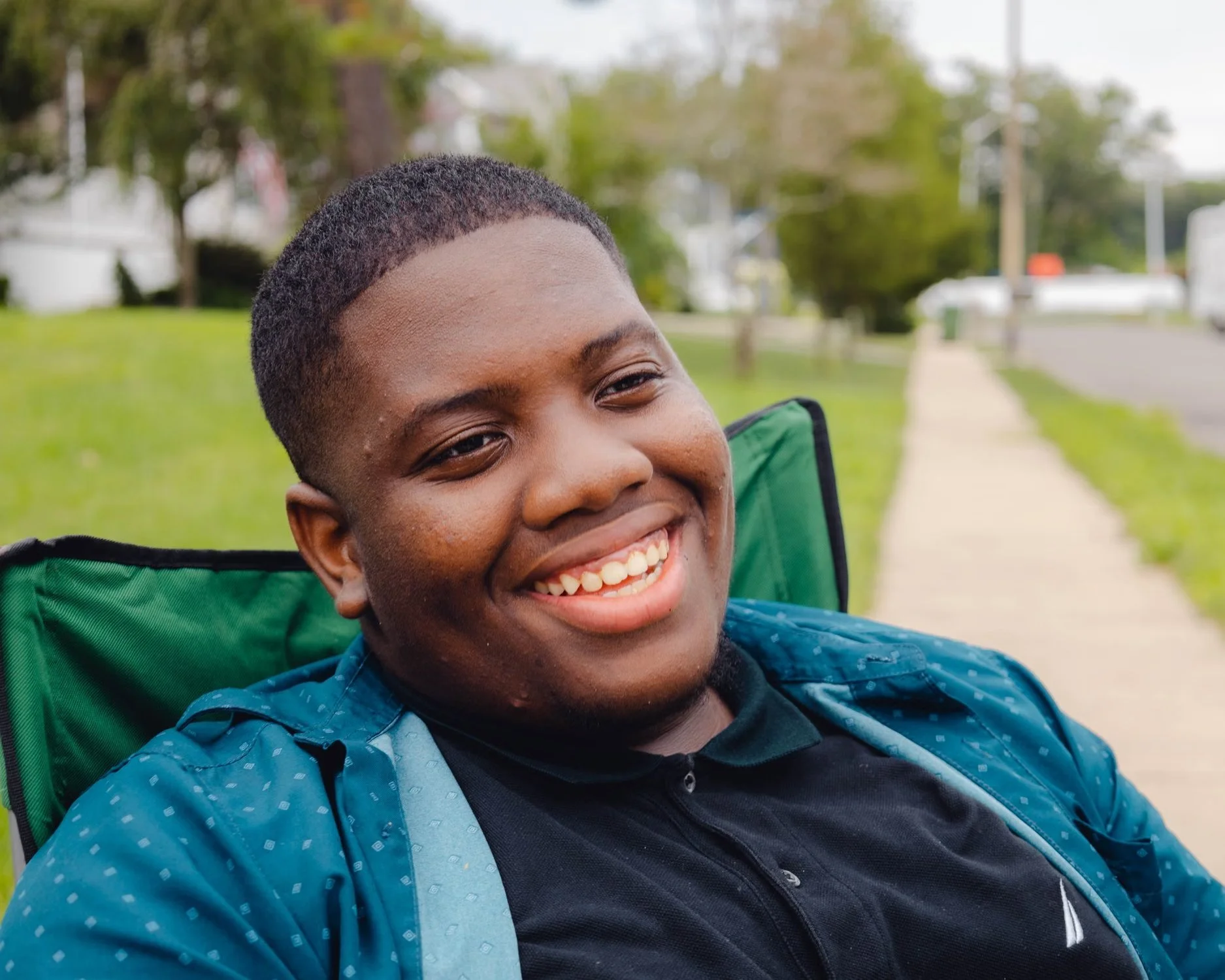 A smiling teenager sitting outdoors