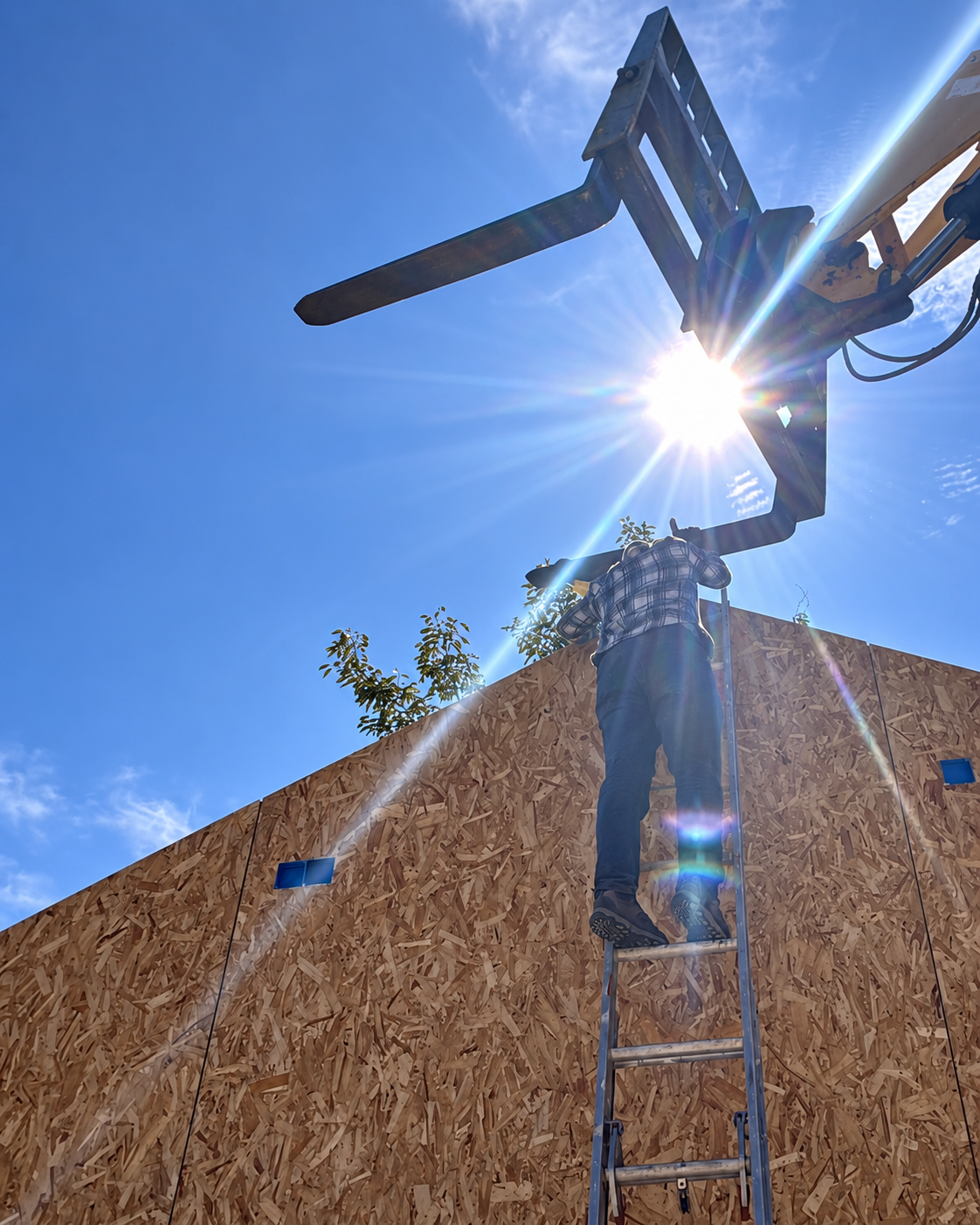 Construction worker guiding the installation of a prefabricated wall on a CSL affordable home
