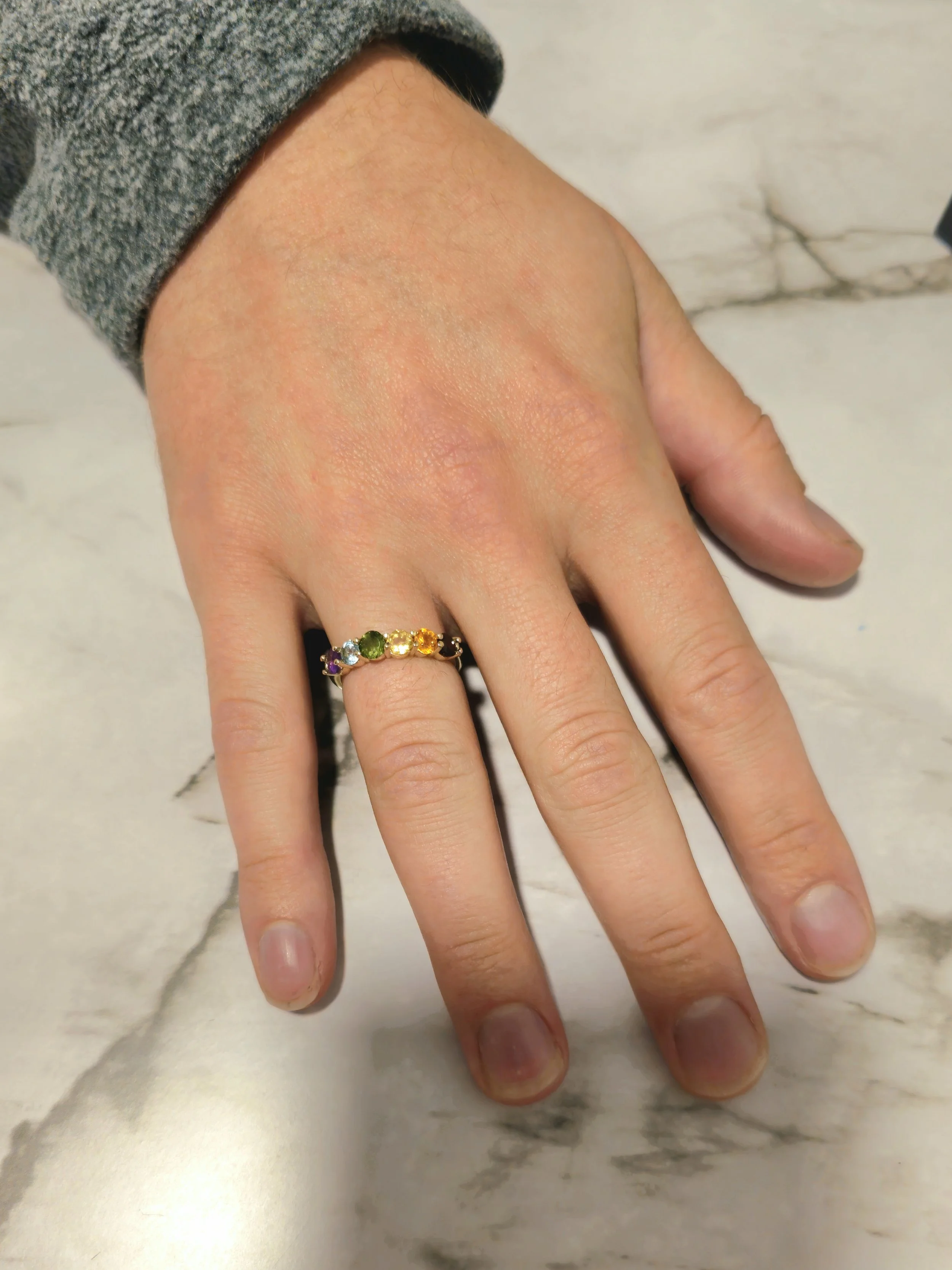 Custom rainbow pride ring worn on hand, made from grandmother's gemstones in 14k yellow gold, designed by A. D'Mae Diamonds Los Angeles