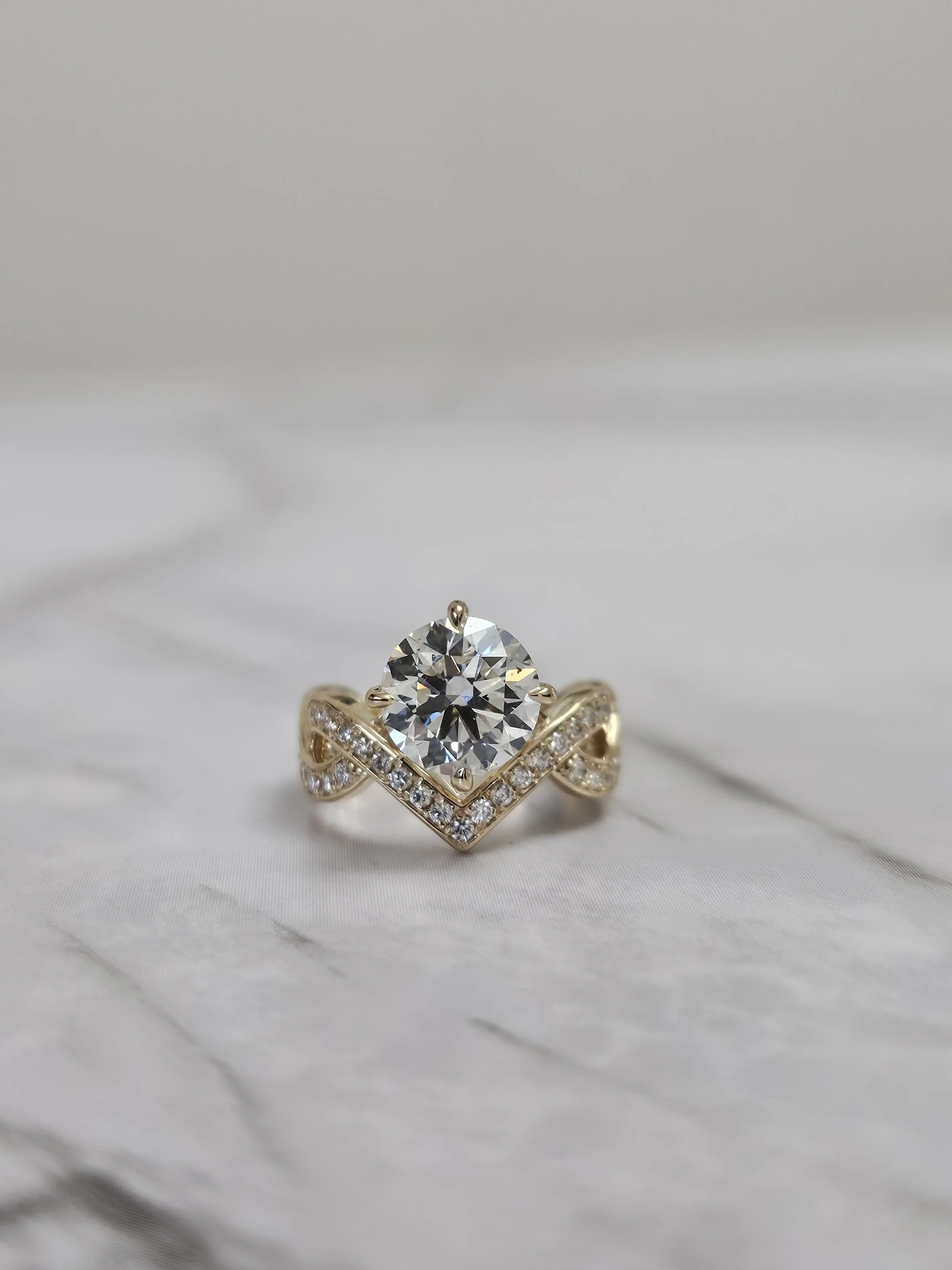 Custom round brilliant engagement ring with infinity twist band