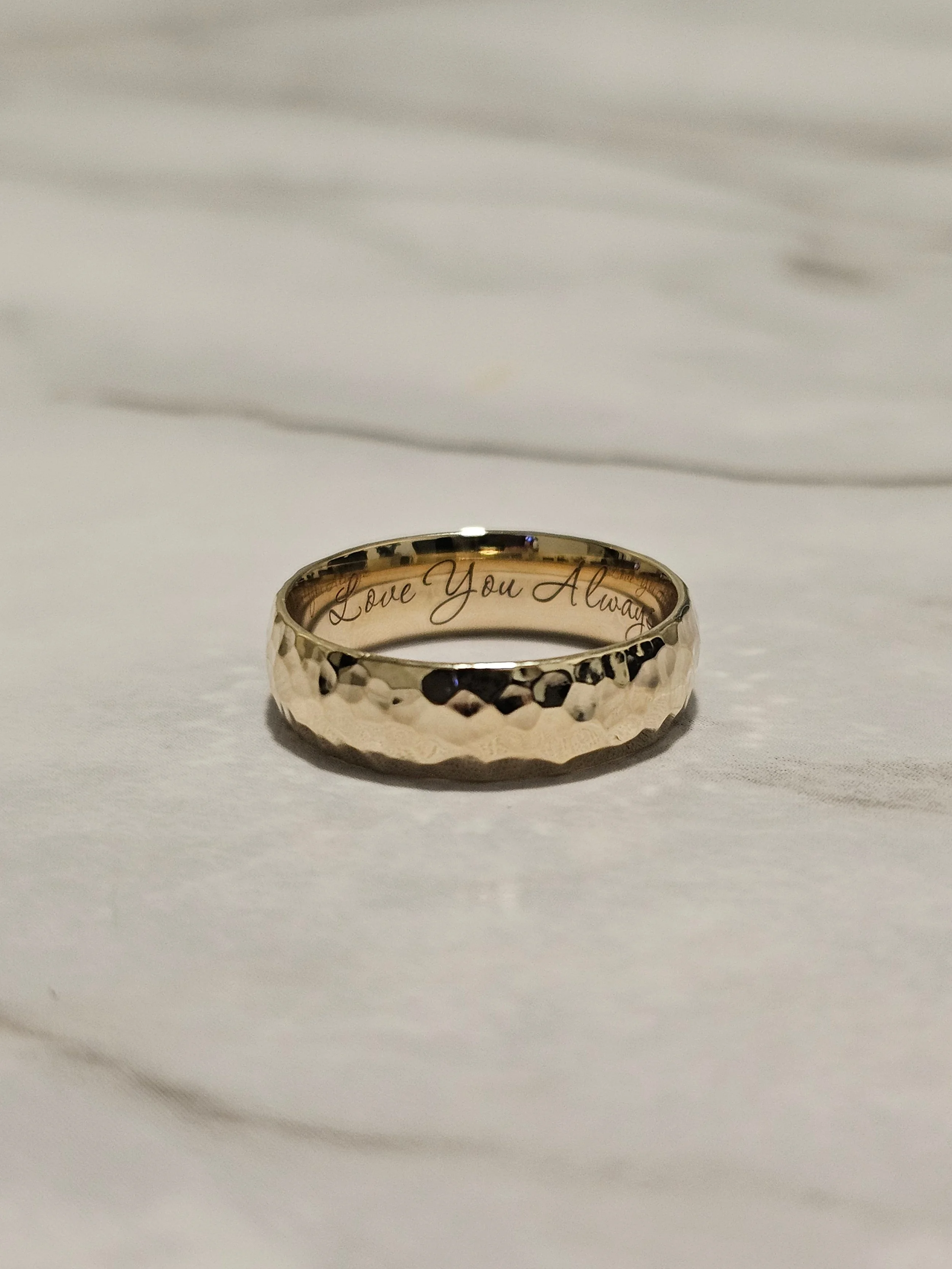 Custom men's wedding band in 14k gold with textured indentations and hidden interior engraving by A. D'Mae Diamonds