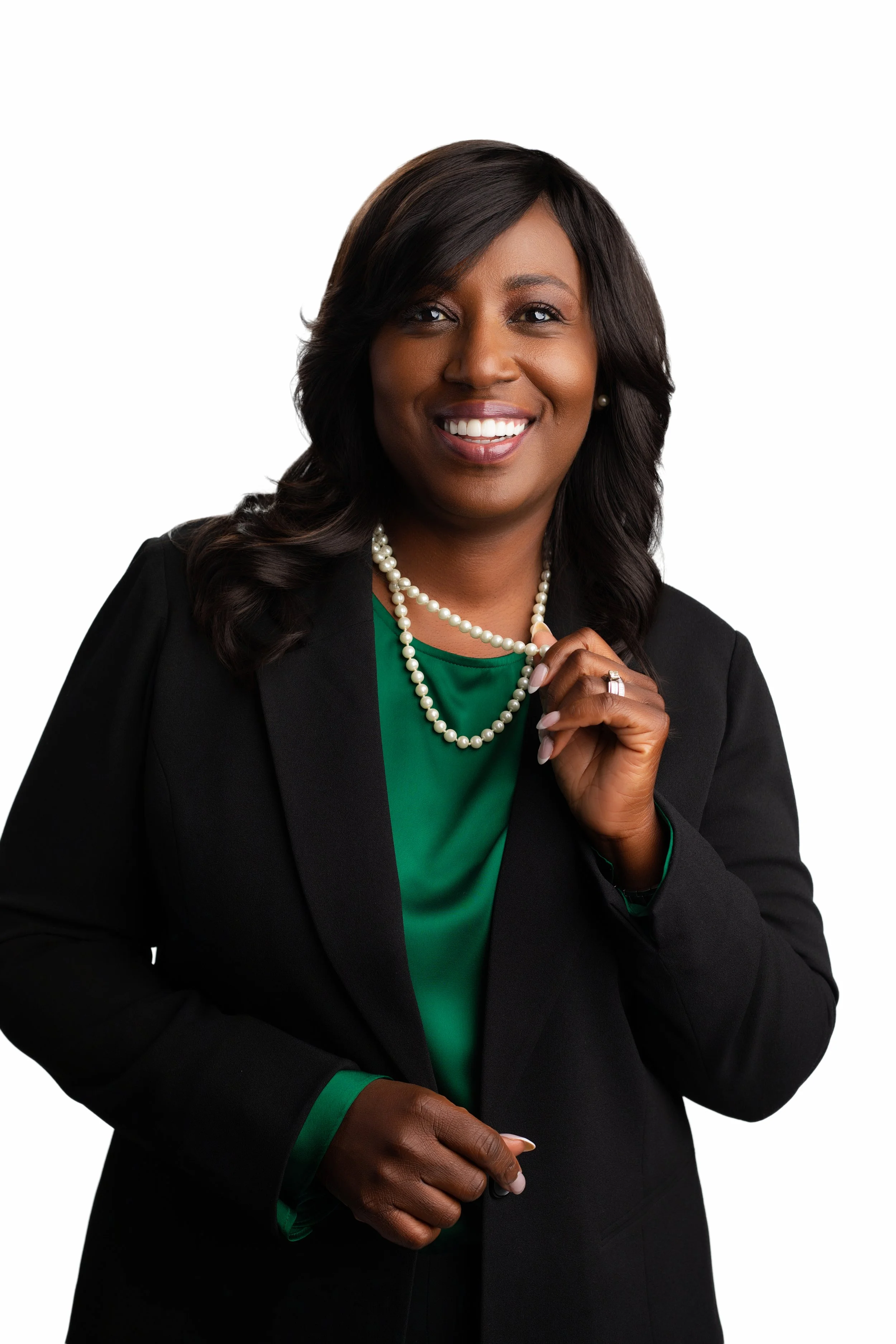 Crisp headshot of an African American woman with a bright smile, black blazer, and emerald green top.