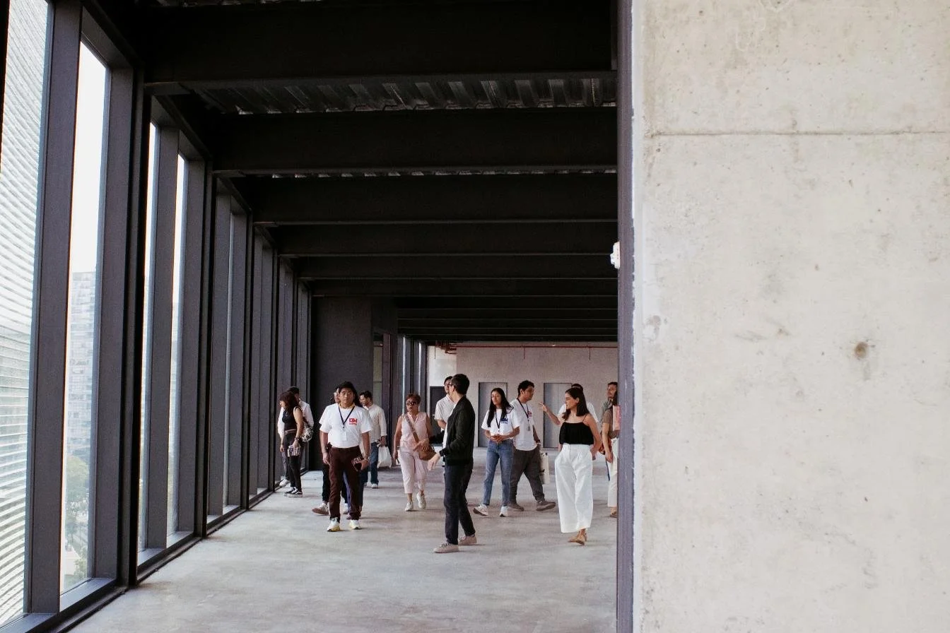 Pasillo abierto de Ferrocarril de Cuernavaca, con estructura de acero y un grupo de visitantes recorriéndolo.
