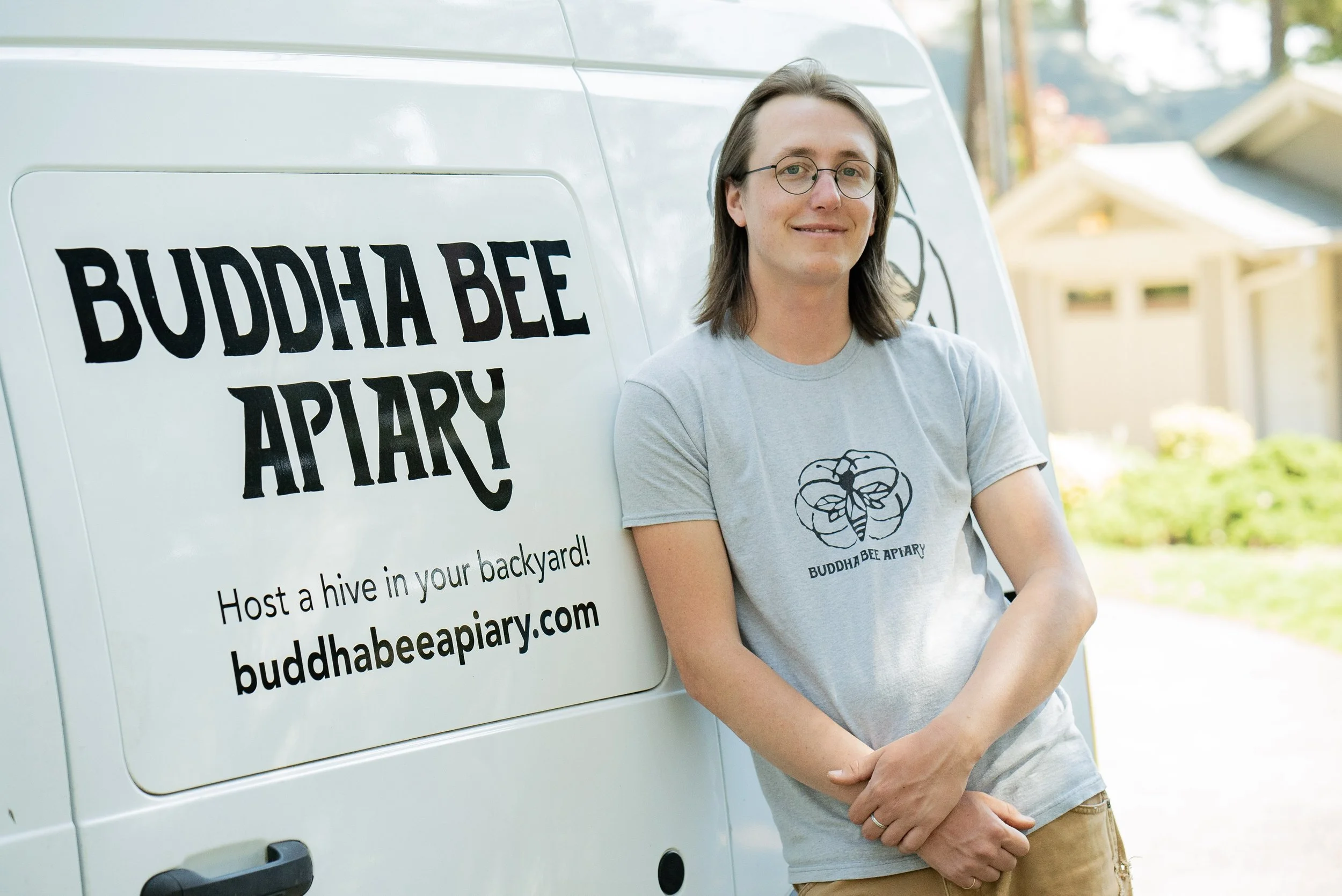 Buddha Bee team member leaning on the company van