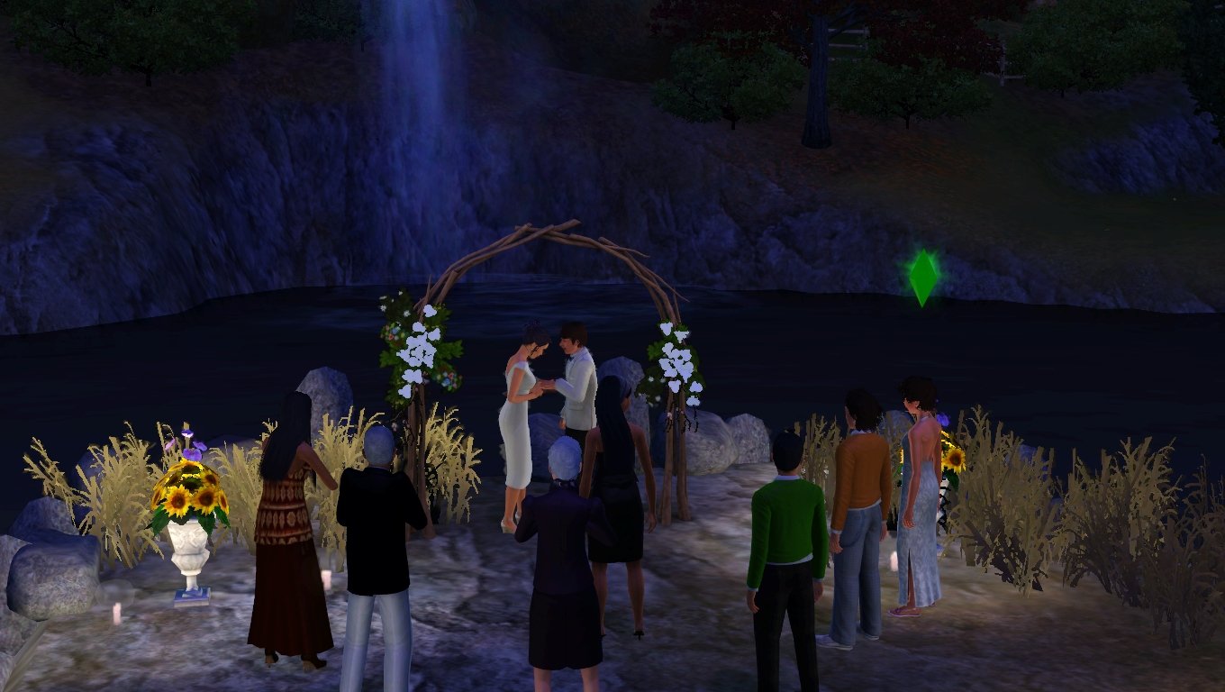 In front of Cinnamon Crest Falls, under a wedding arch, Dorothy slips a ring onto Matthew’s finger while a crowd watches, including Sage, Altman, Bridget, Emery, Mason, Ryker, and Aria.