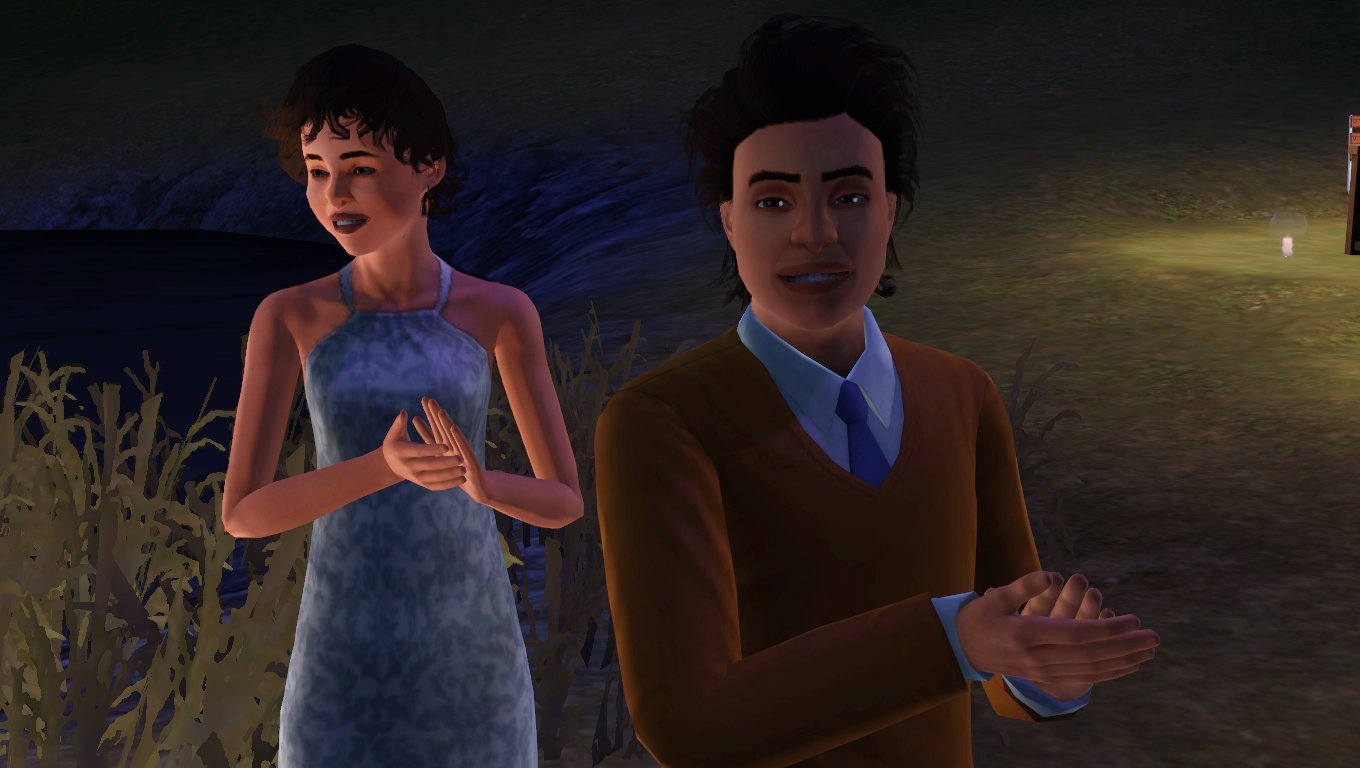 Aria and Ryker Tevellyn smiling and clapping. Aria wears a long silver dress with a slim fit and halter neckline. Ryker wears an orange sweater over white dress shirt with a blue tie.