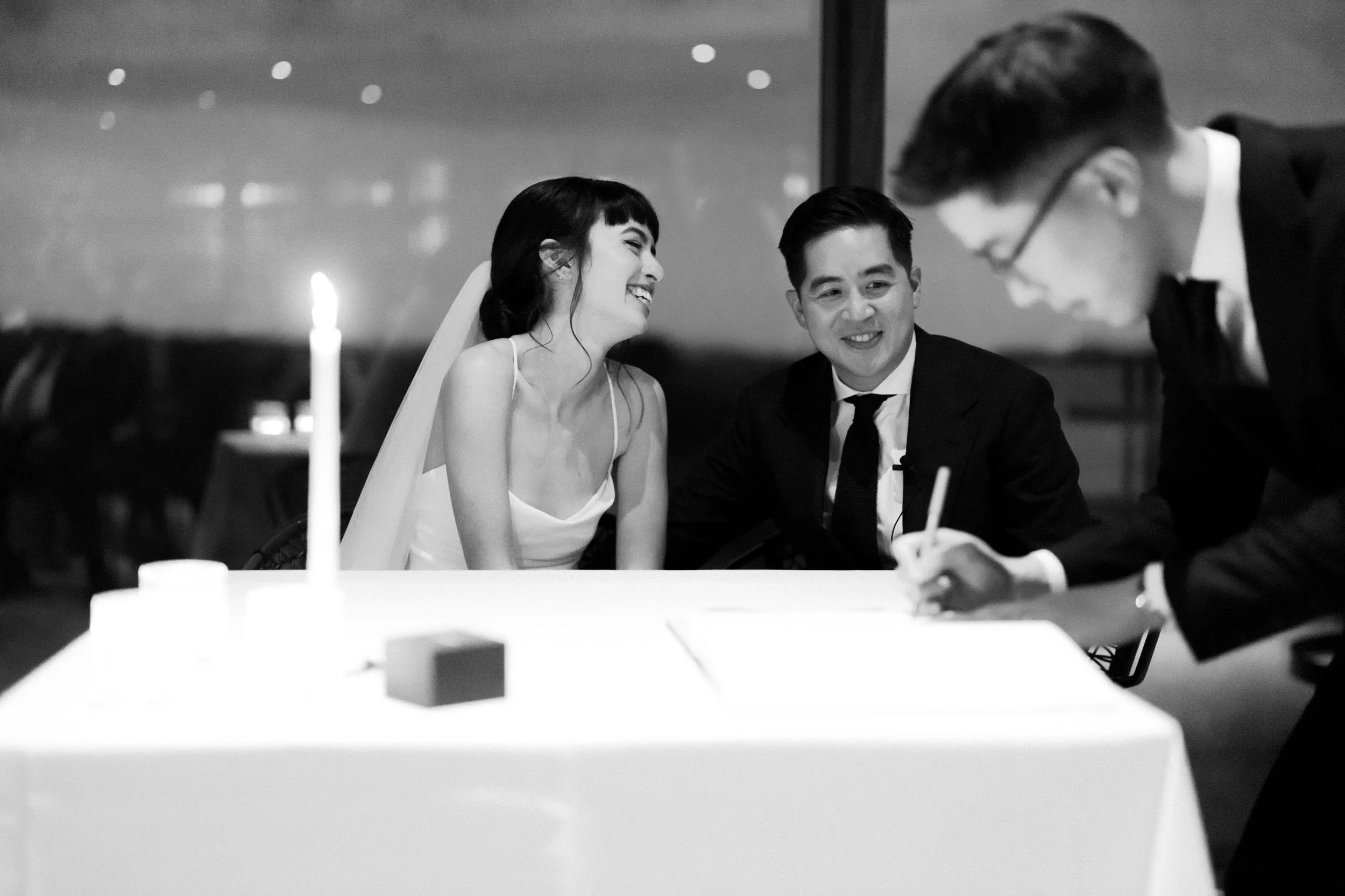 Couple signing wedding documents by candlelight