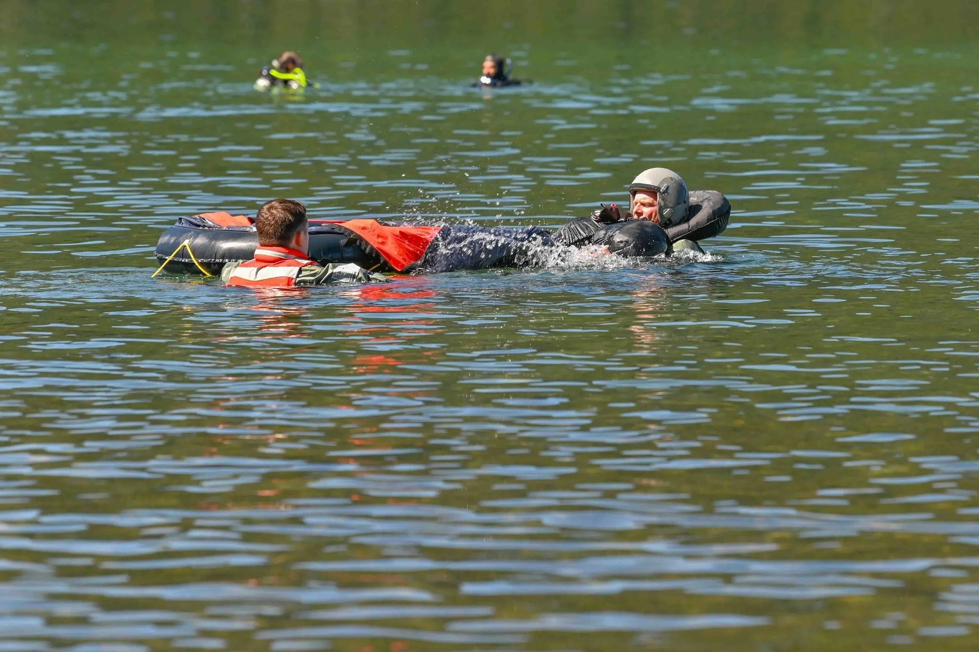 Aircrew member in flotation gear climbing from the water into a life raft during water-survival training