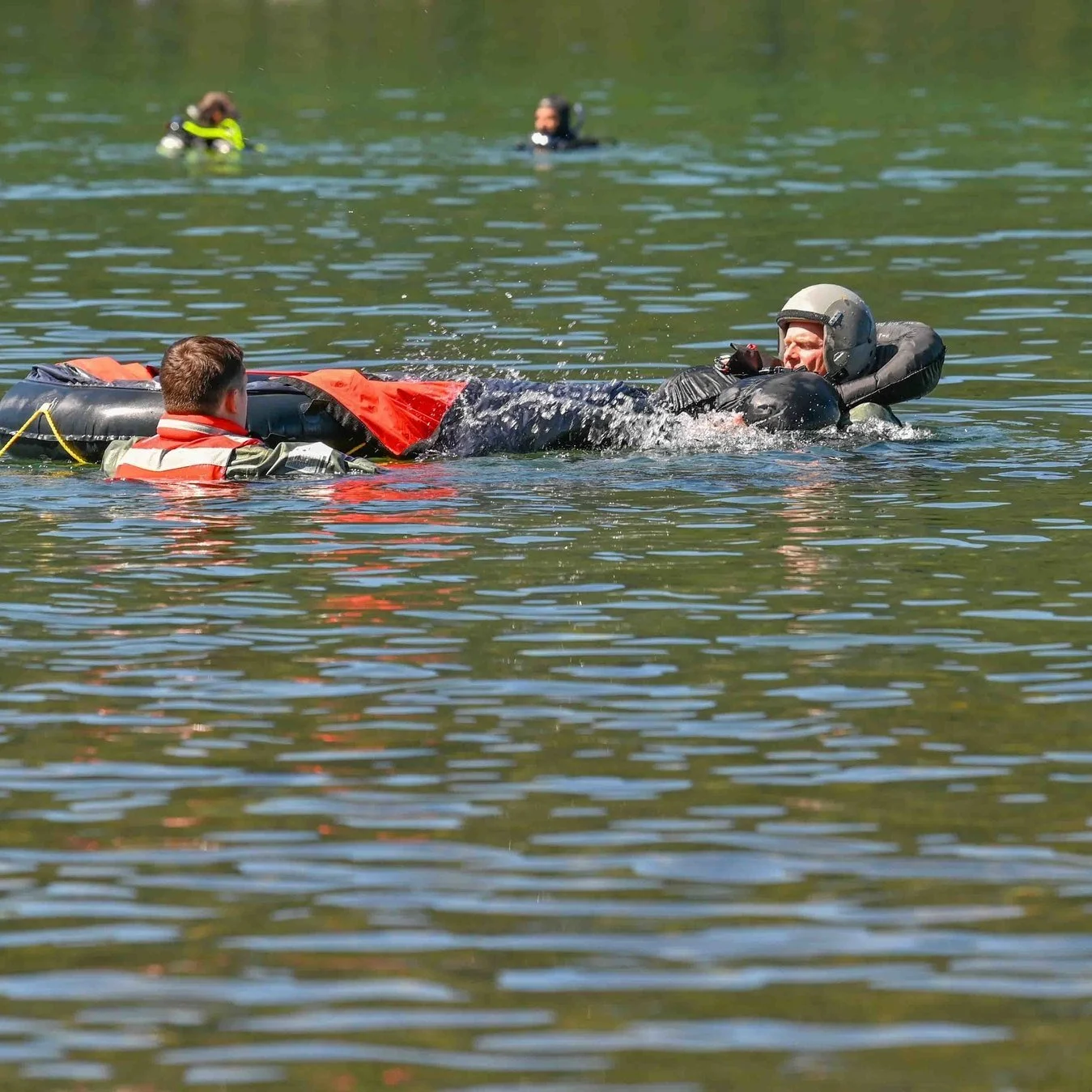 Aircrew member in flotation gear climbing from the water into a life raft during water-survival training