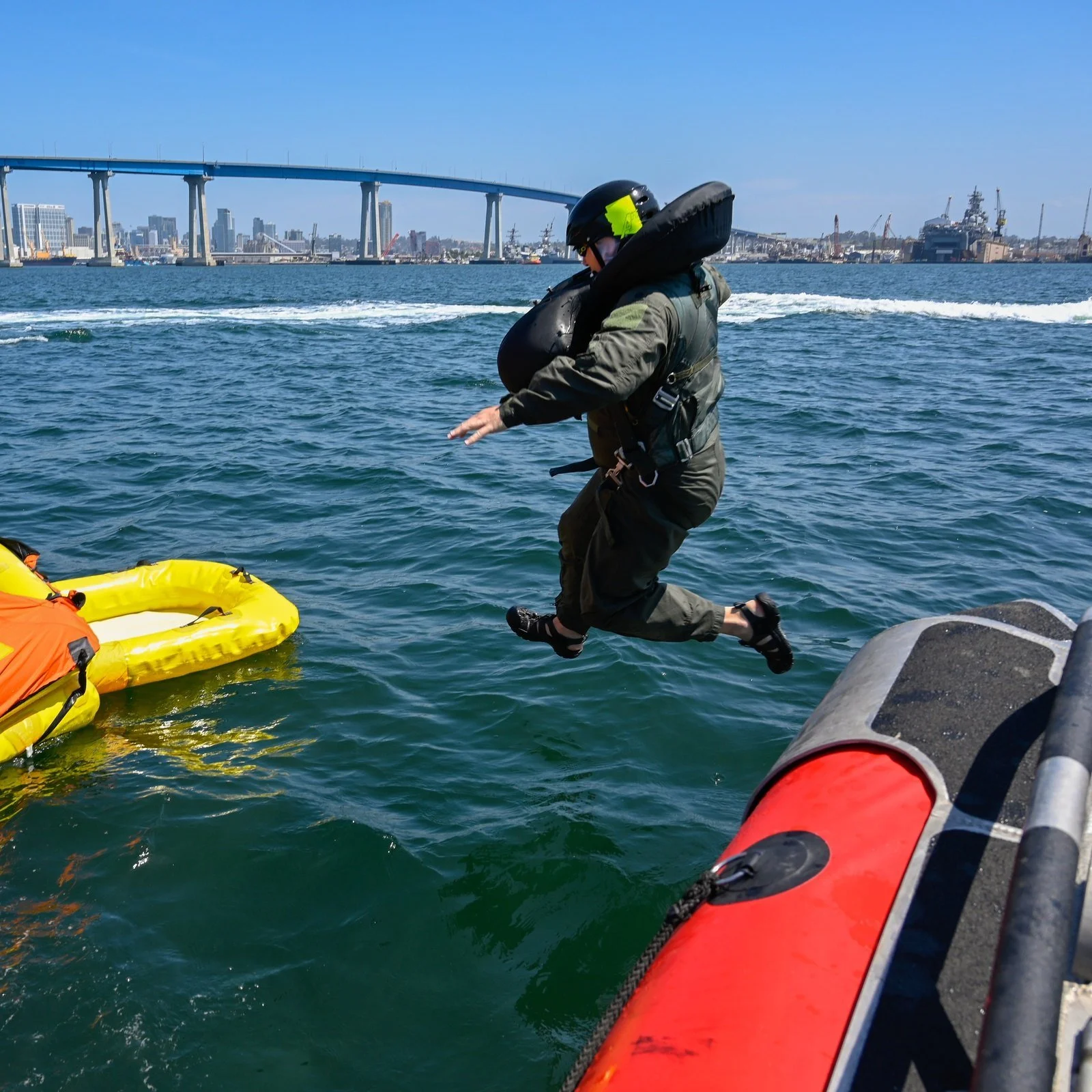 Aircrew flight equipment technician moving toward a life raft during water-survival and helicopter-extraction training