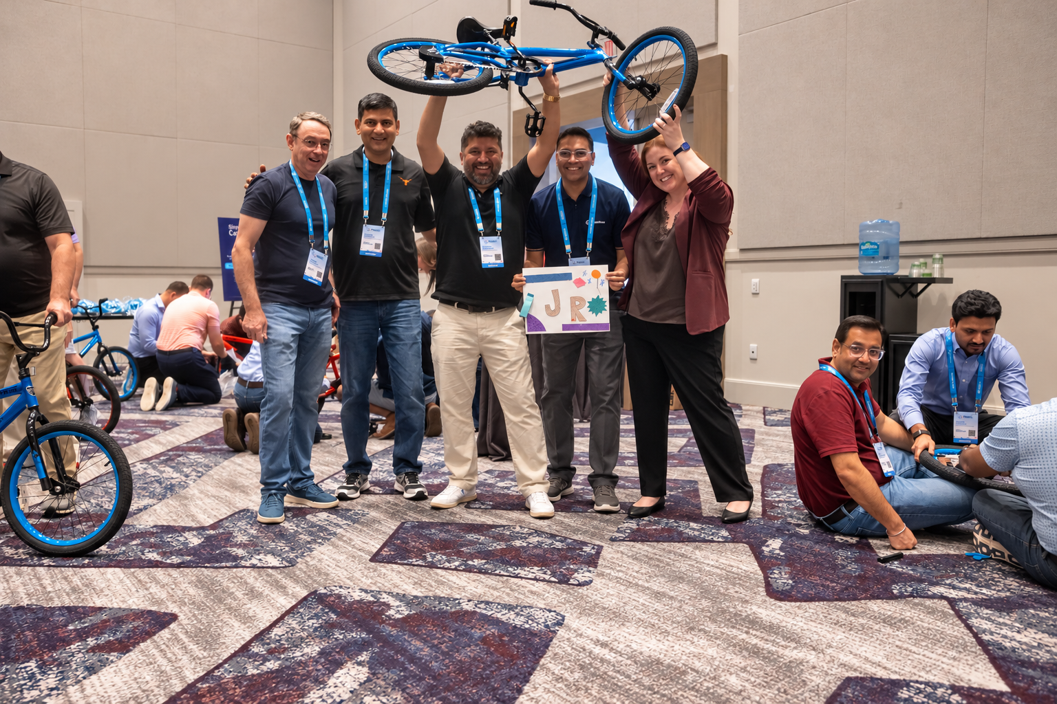 A team celebrates with an assembled bicycle.