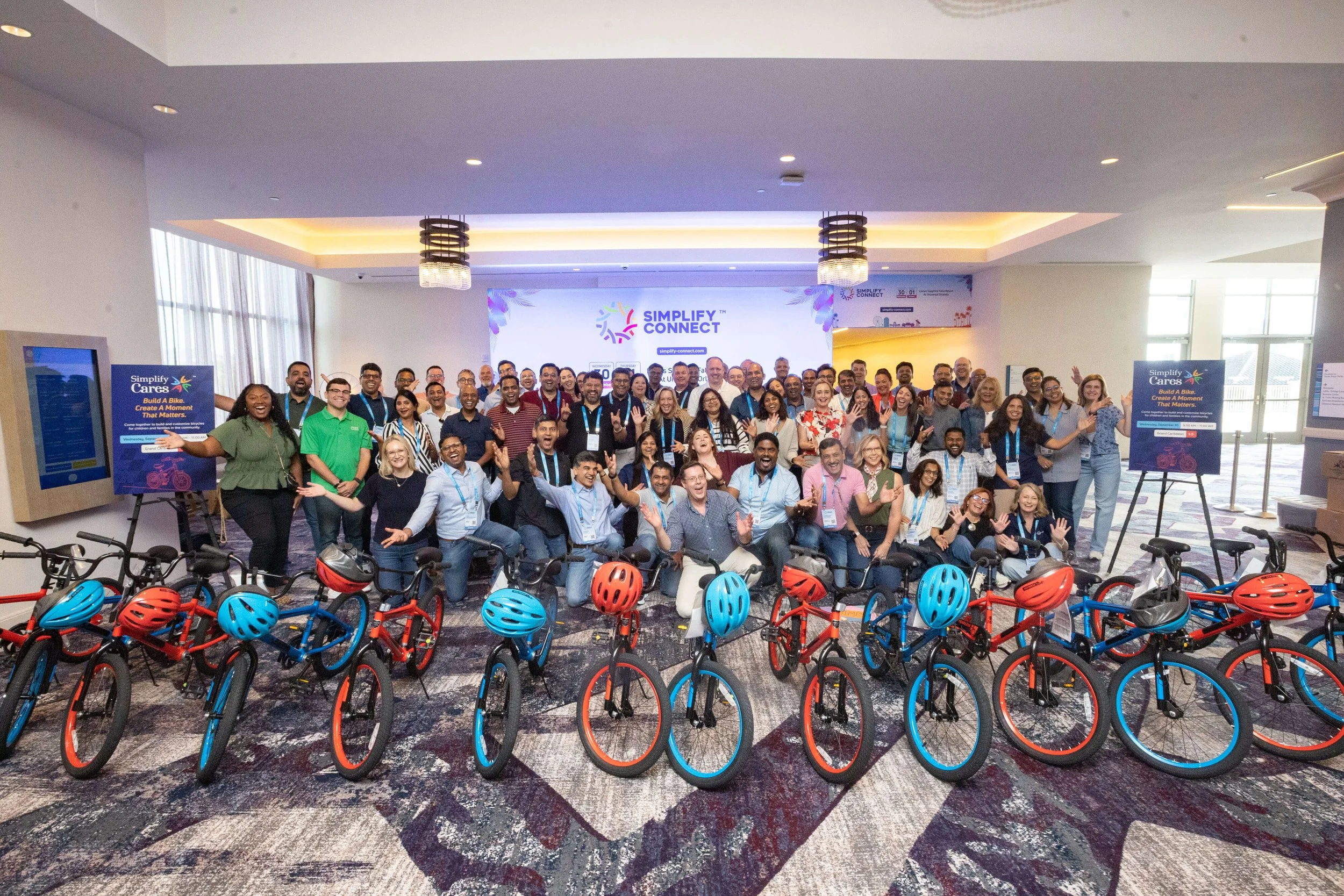 The event participants gather behind the completed bicycles and helmets.