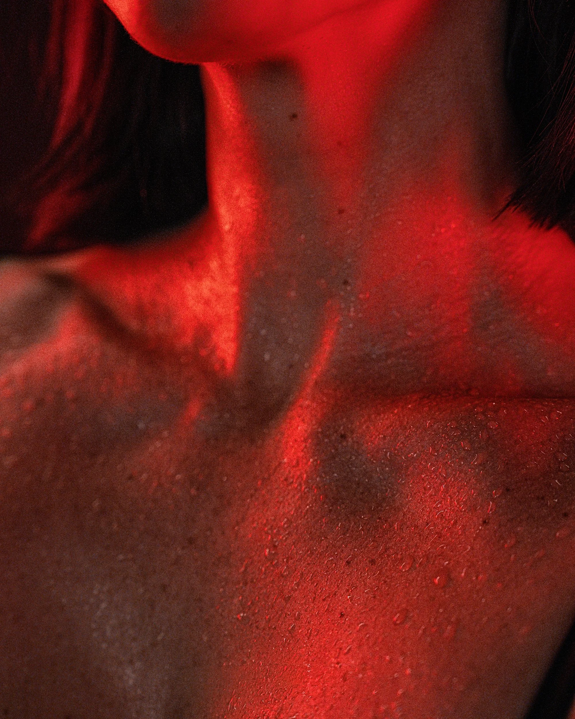 The Burn Room campaign photograph by Navaji David Nava showing a close study of neck and collarbone in red light