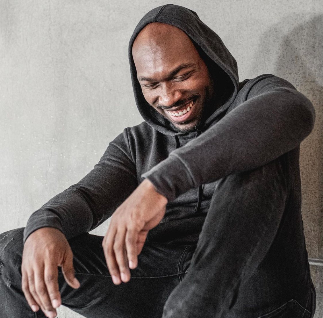 CJ Johnson laughing in a black hoodie