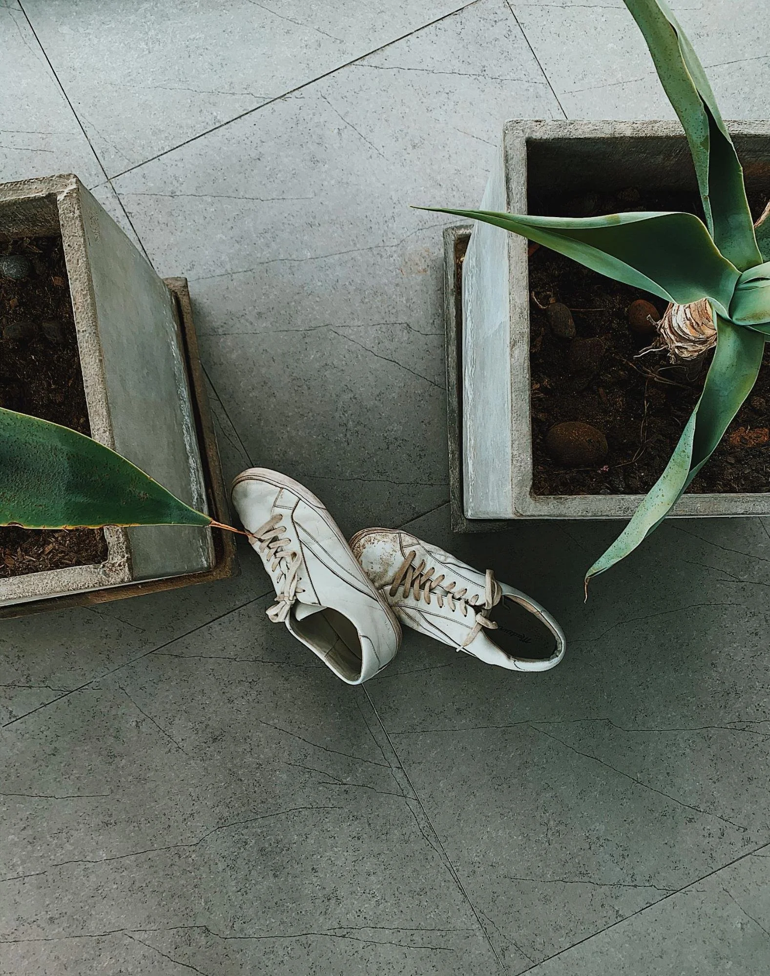 White sneakers on stone tile
