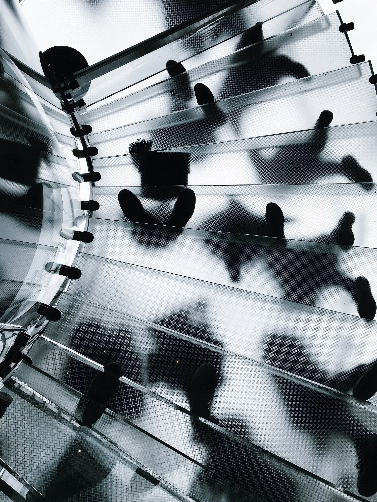 Silhouettes of people on a frosted glass staircase