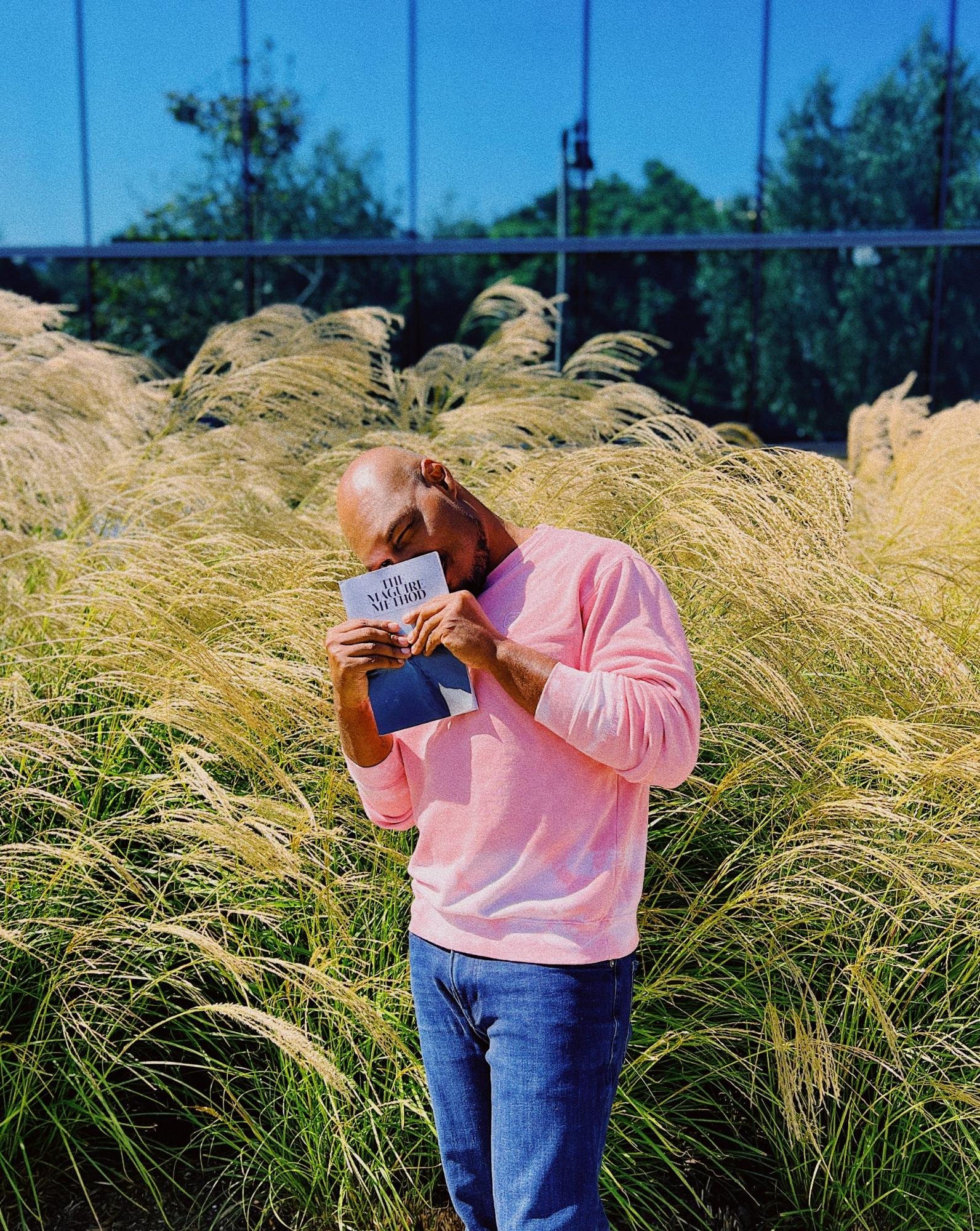 CJ Johnson holding The Maguire Method in a field of tall grass