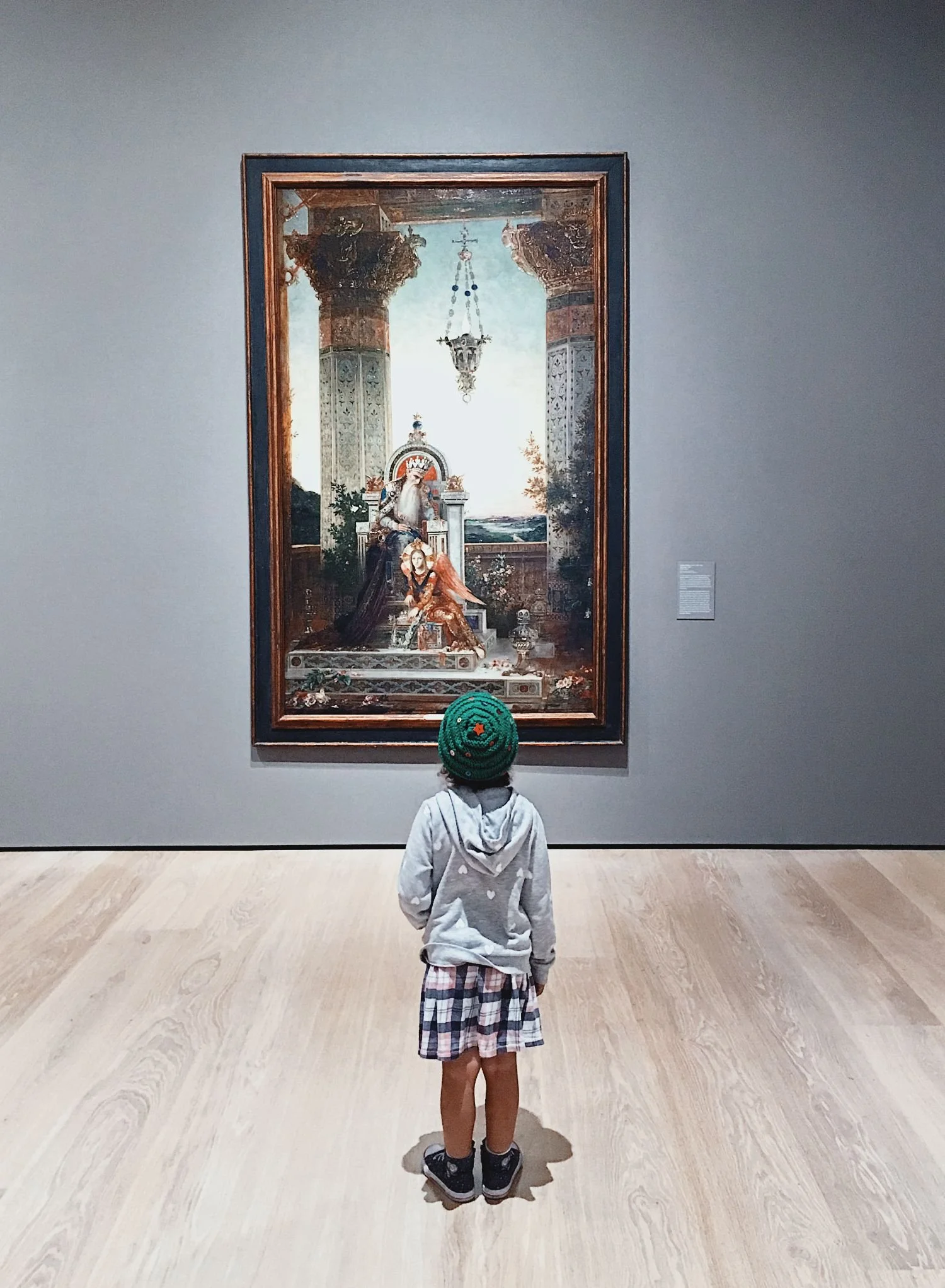 A child looking up at a painting in a museum