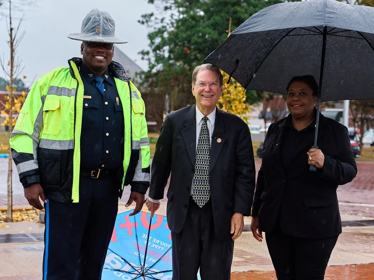 Christie Lindsey with the mayor of Warren and a police officer at a rainy Gratitude Week stop