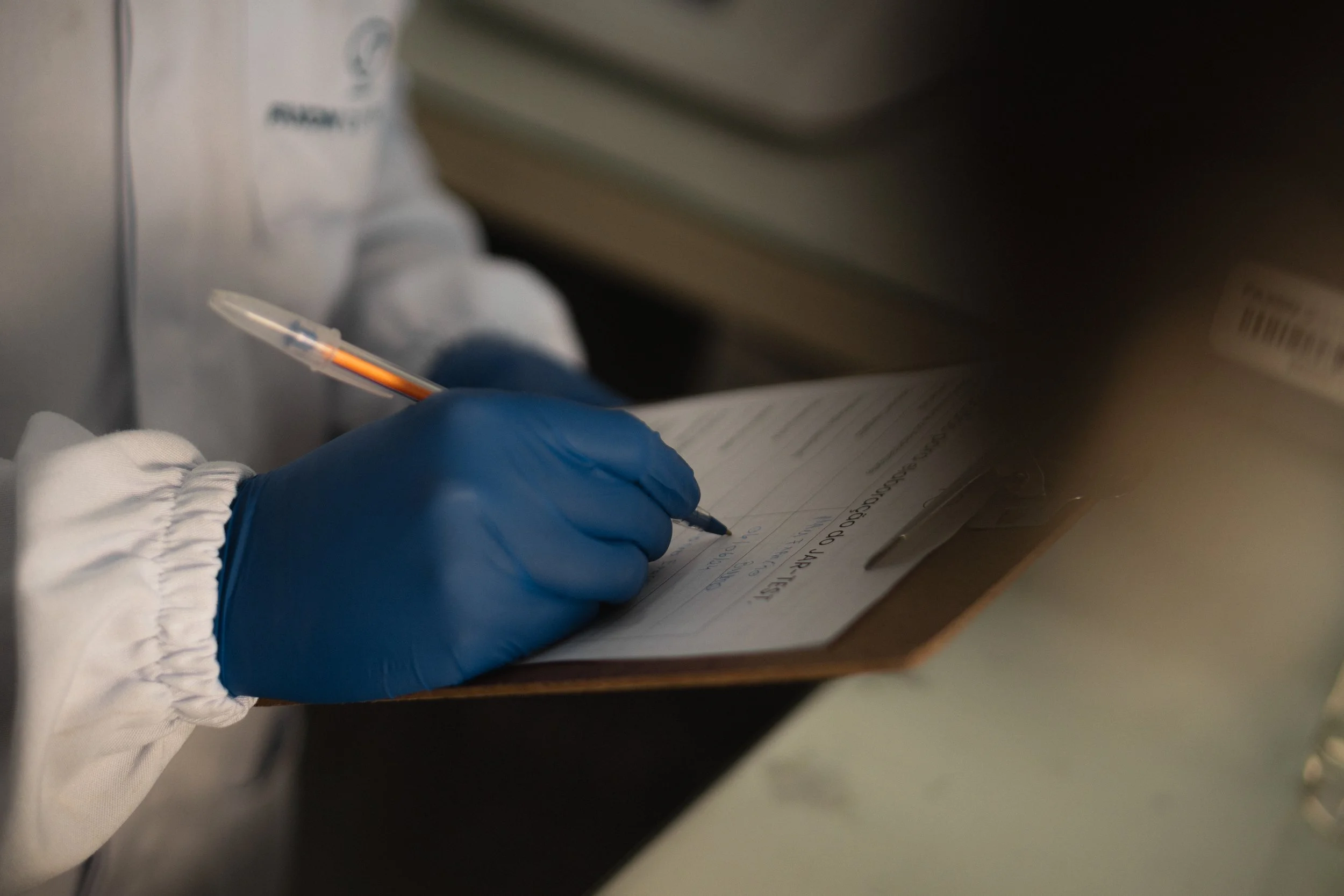 Registro de resultados em prancheta no laboratório da Faxon Química