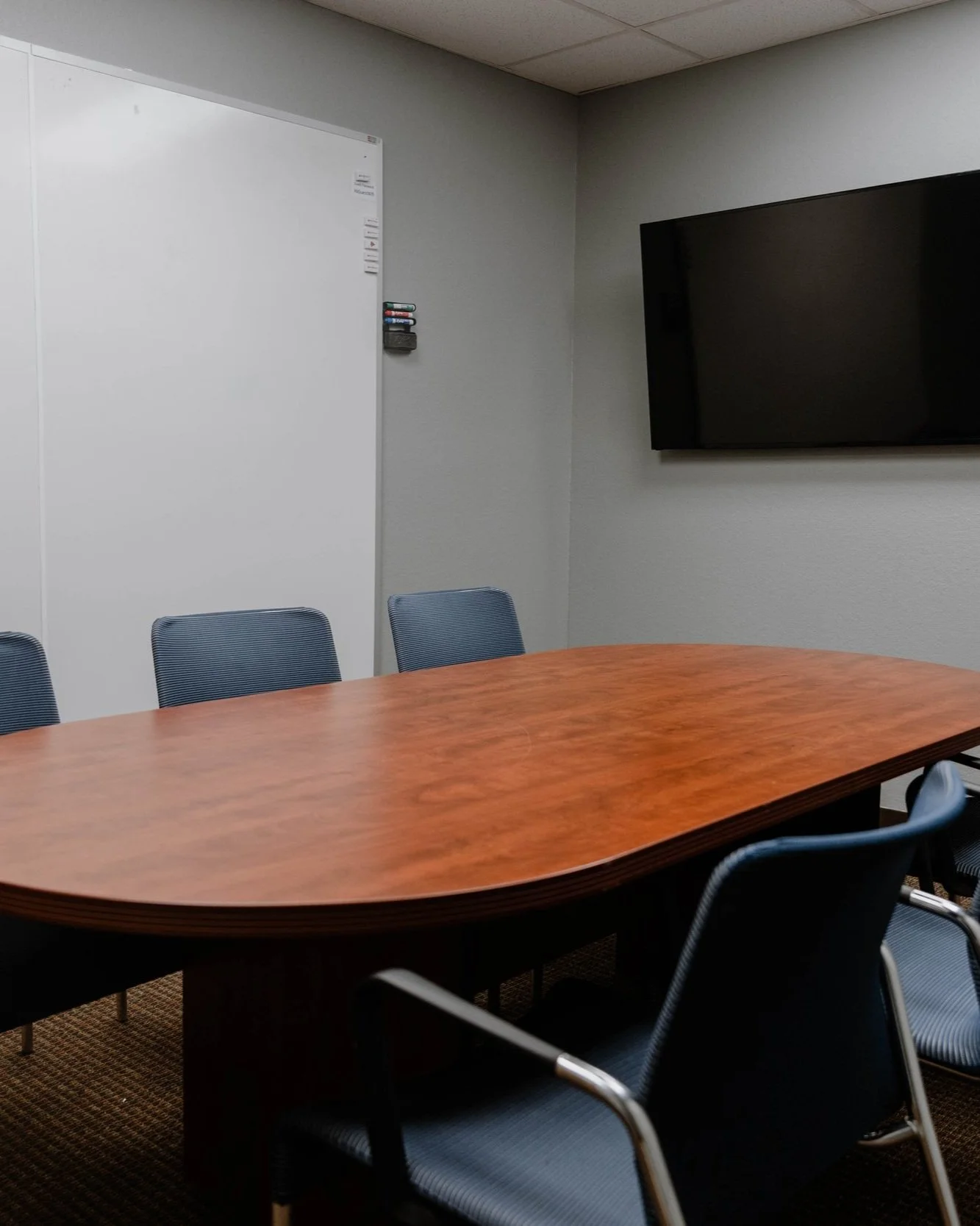 Downtown meeting room with oval table and TV, seats 6