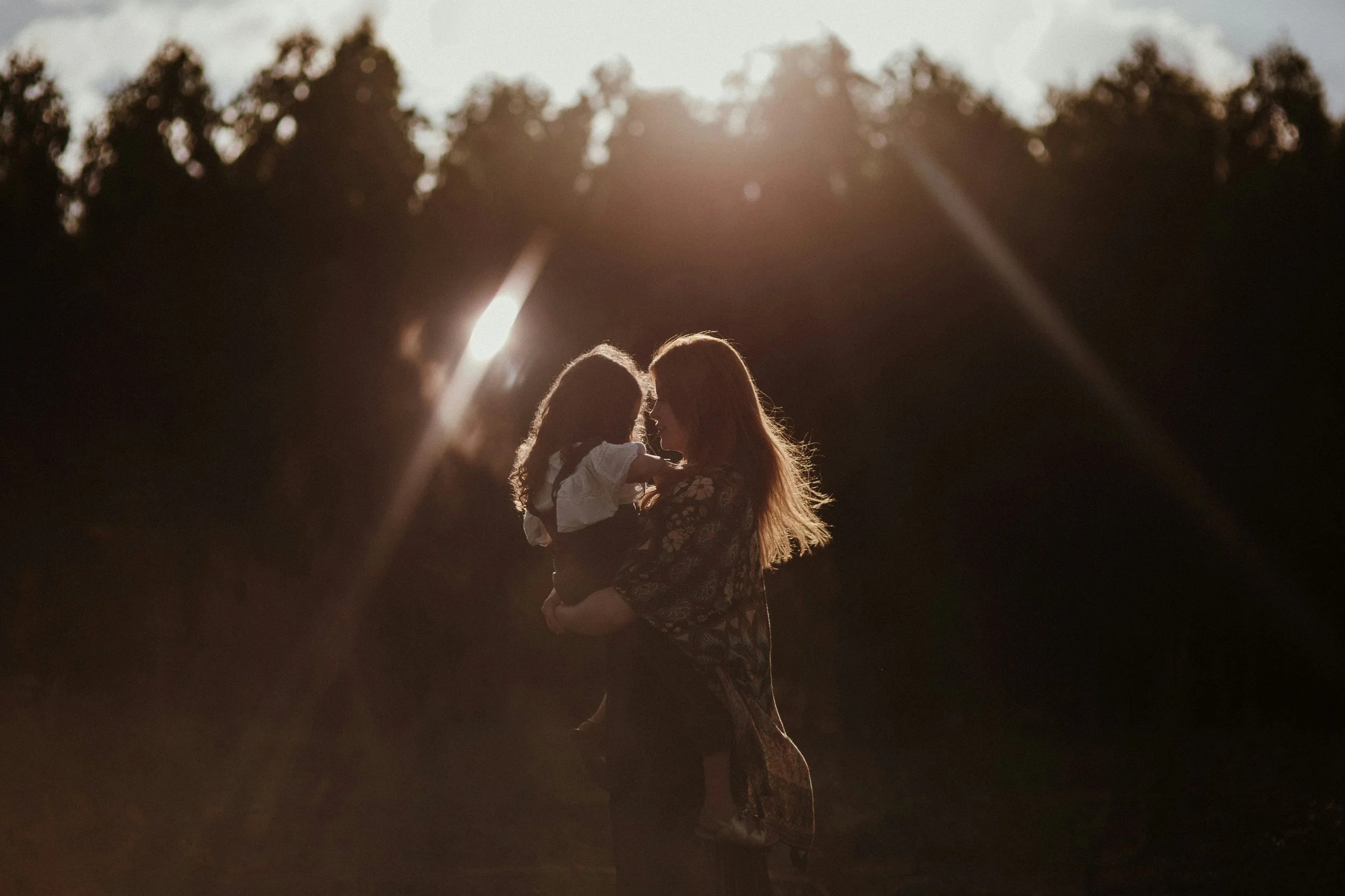 Mother holding child at golden hour