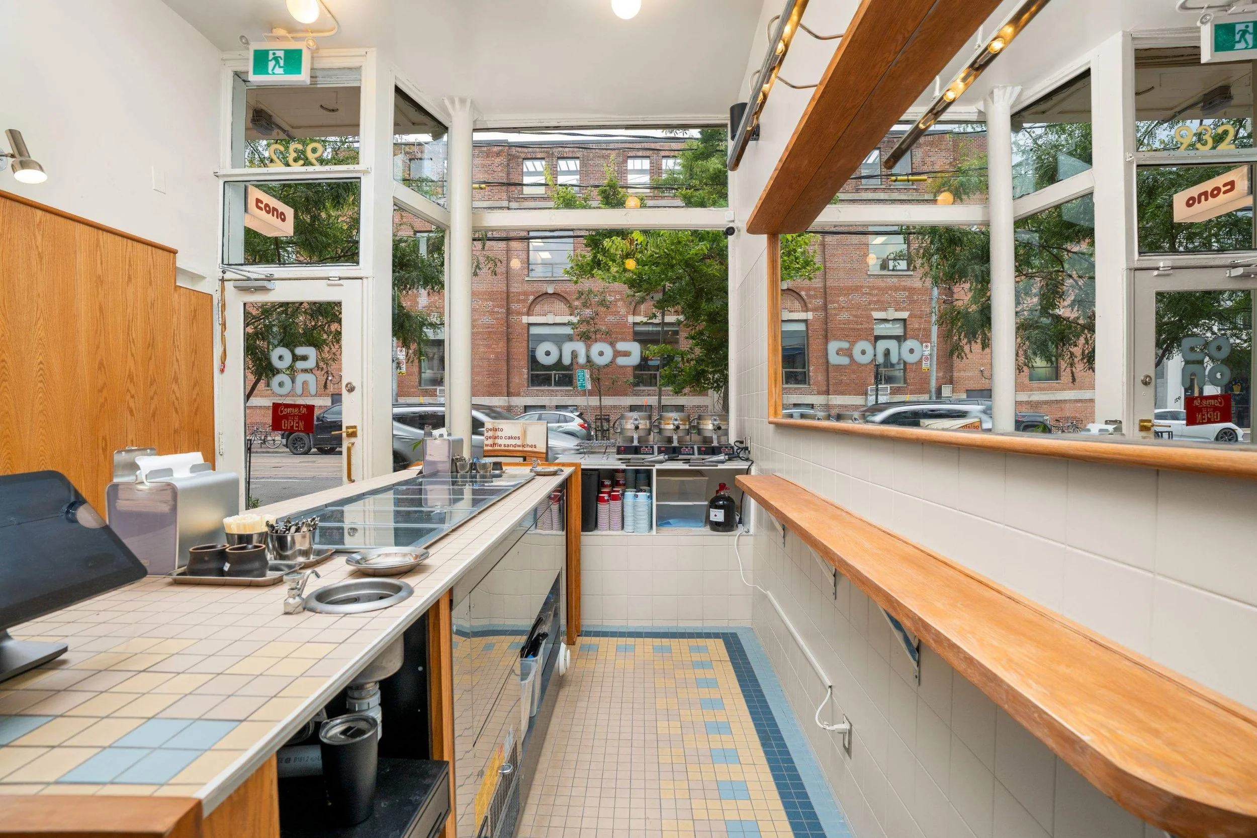 Bright interior of Cono gelato shop with tiled counter, wood ledges and floor-to-ceiling front windows.
