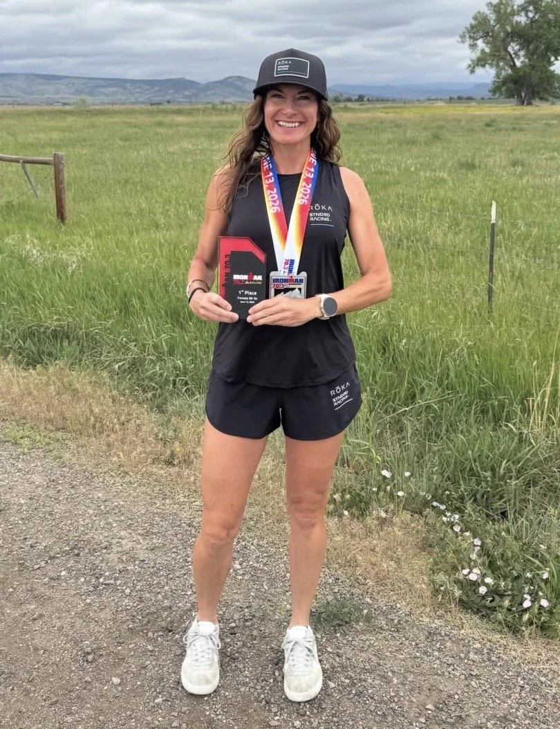 Tracy Campbell holding her race award and wearing finisher medals