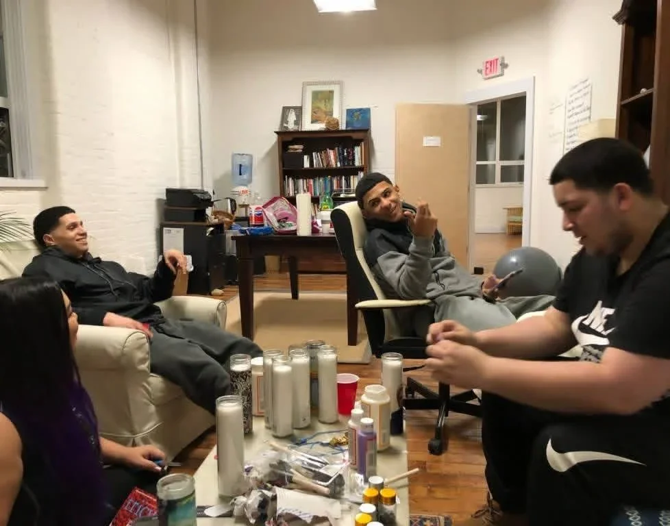Participants in conversation around a table in a shared room.