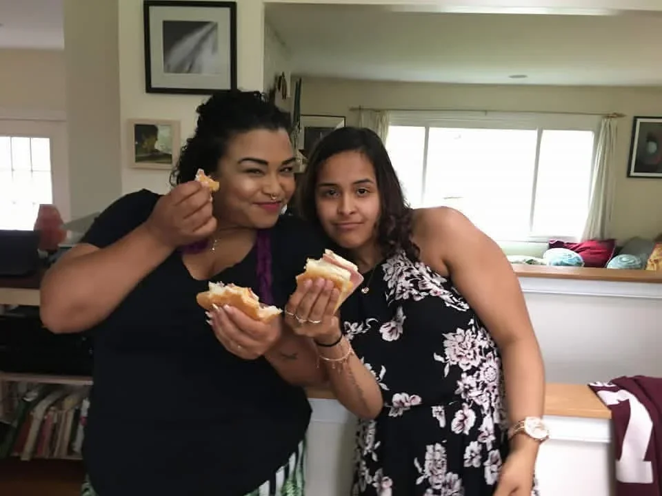 Two participants sharing food at an indoor gathering.