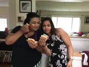 Two participants sharing food at an indoor gathering.