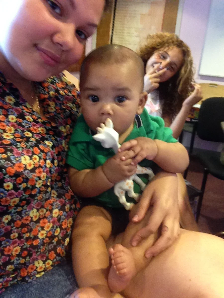 An adult and baby during an indoor gathering.