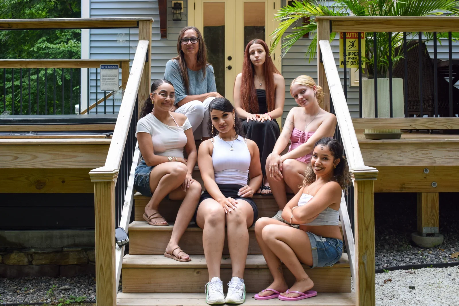 A group gathered on the steps of a wooden porch.