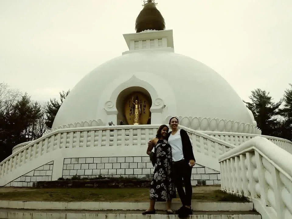 A person standing in front of a white peace pagoda.