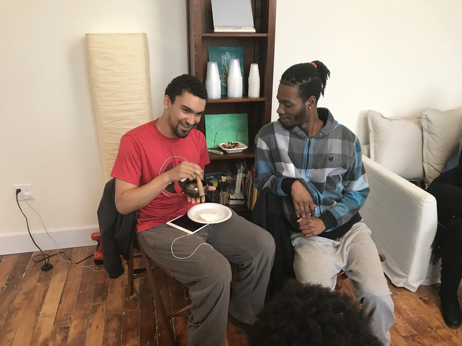 Two participants seated together with refreshments and a dog.