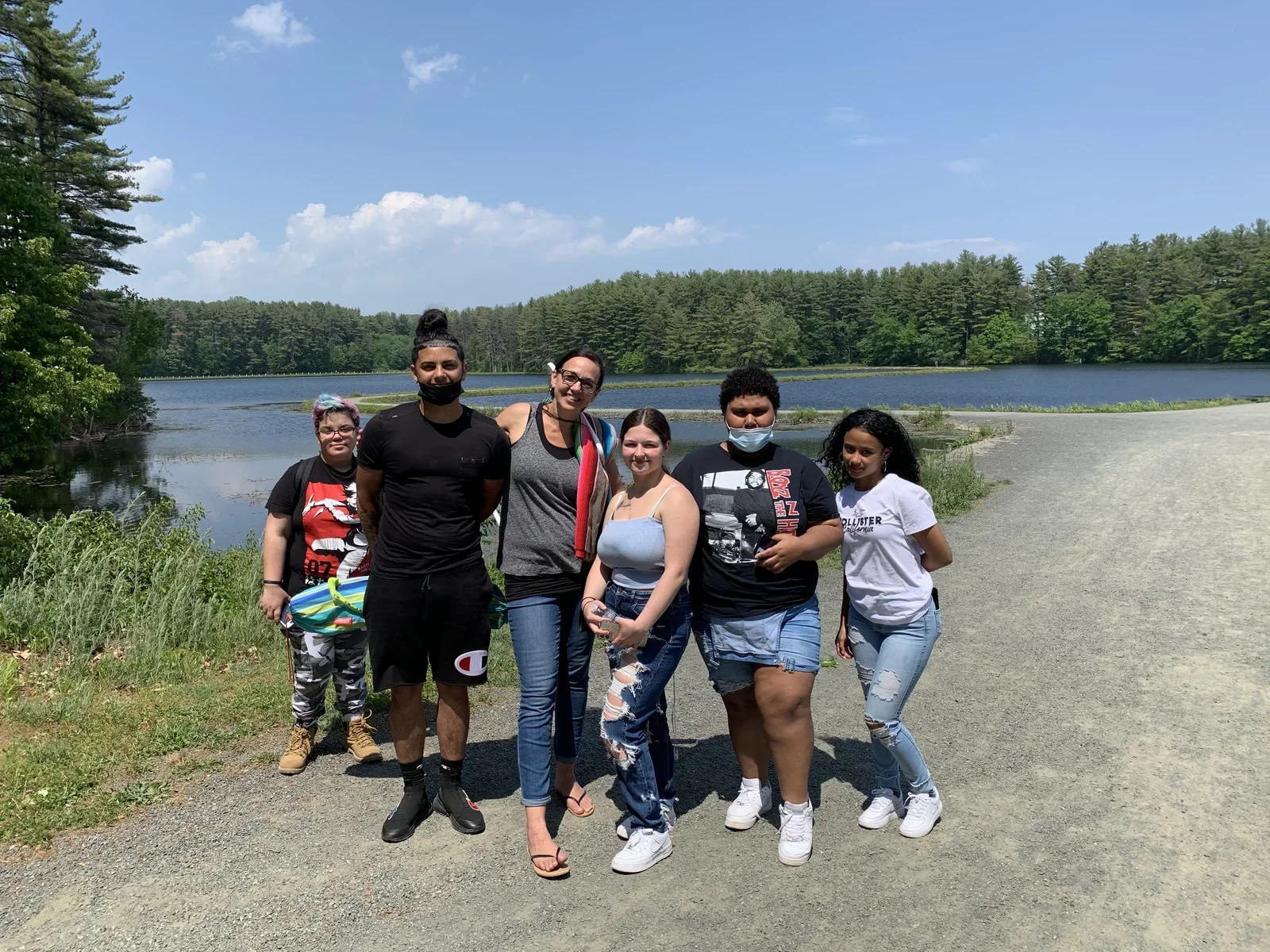 A group gathered on a trail overlooking a reservoir.