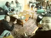 A group sharing refreshments around a living-room table.
