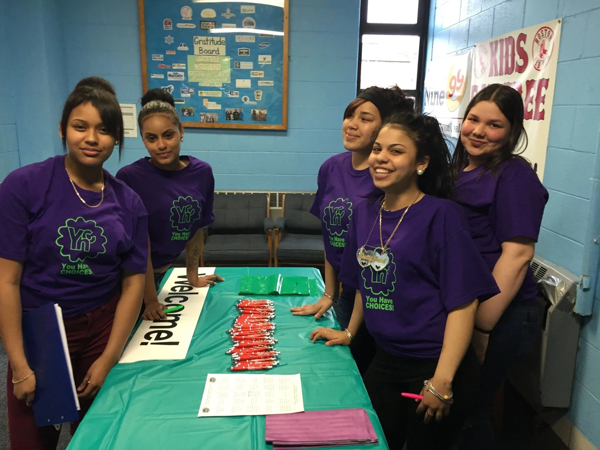 Cinco jóvenes en una feria de salud comunitaria en Holyoke.