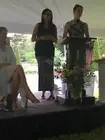 Two participants speaking at lecterns on a covered porch.