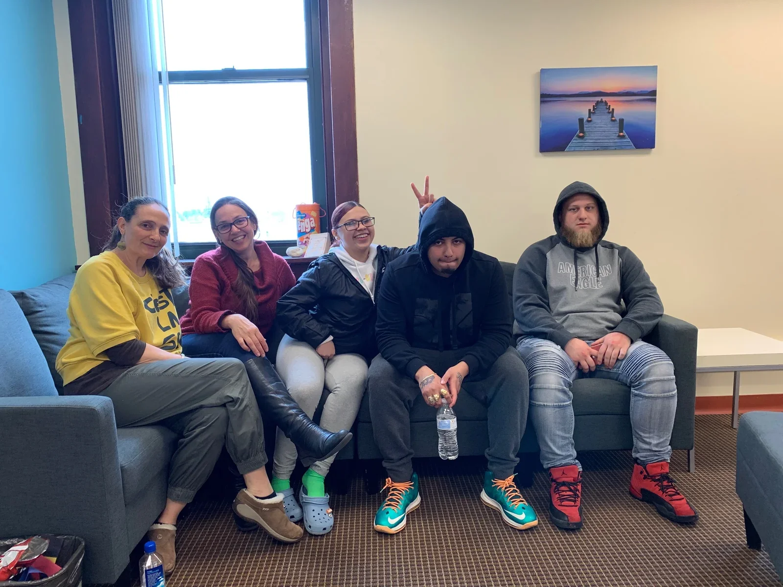 Five participants sharing a relaxed moment on a couch.